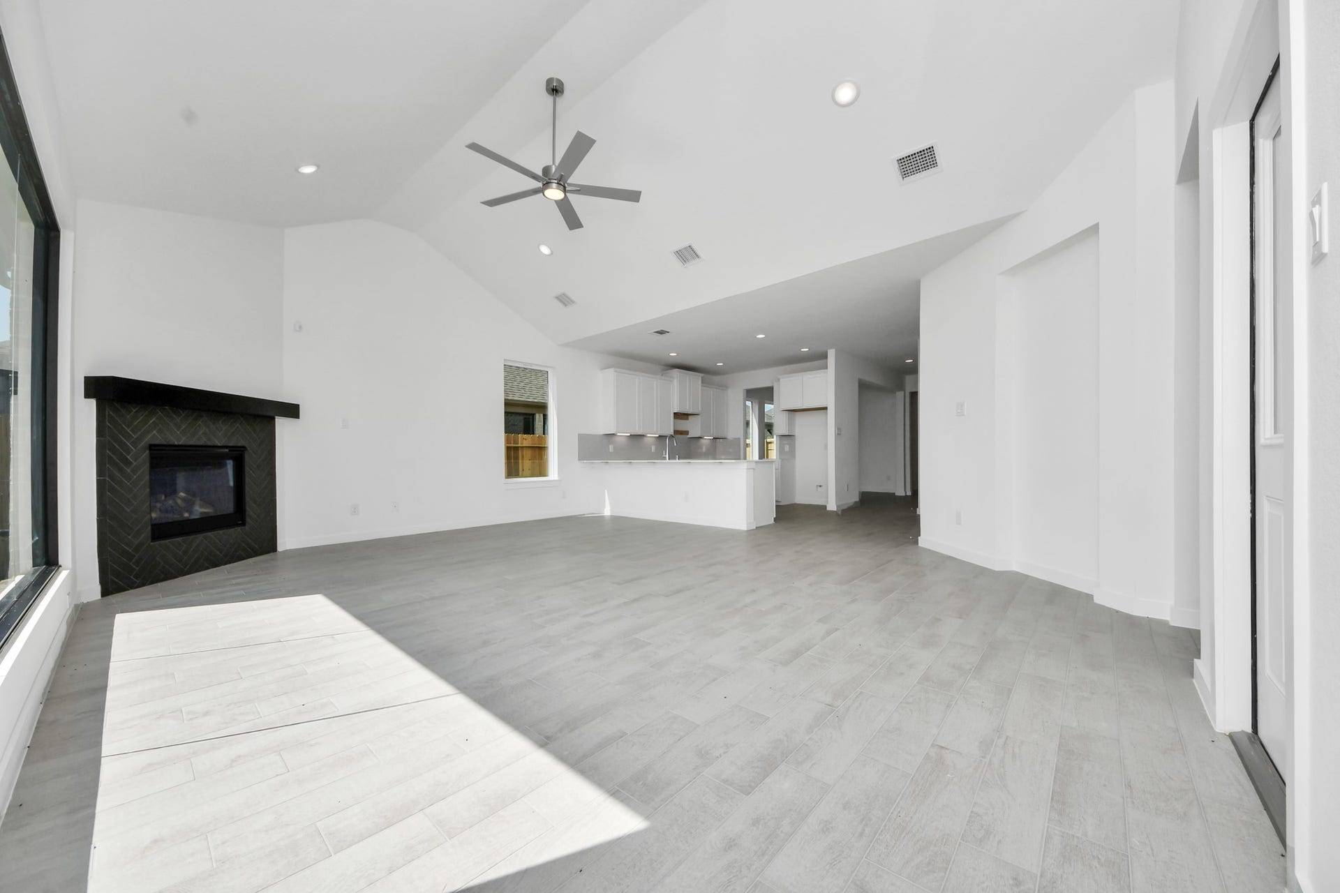 3072 Spoolwood Trail, Magnolia, TX 77355 Family room flooded with natural light through the expansive windows. The premium tile flooring adds a touch of luxury to the space, creating the perfect setting for relaxing moments and cherished gatherings with loved ones