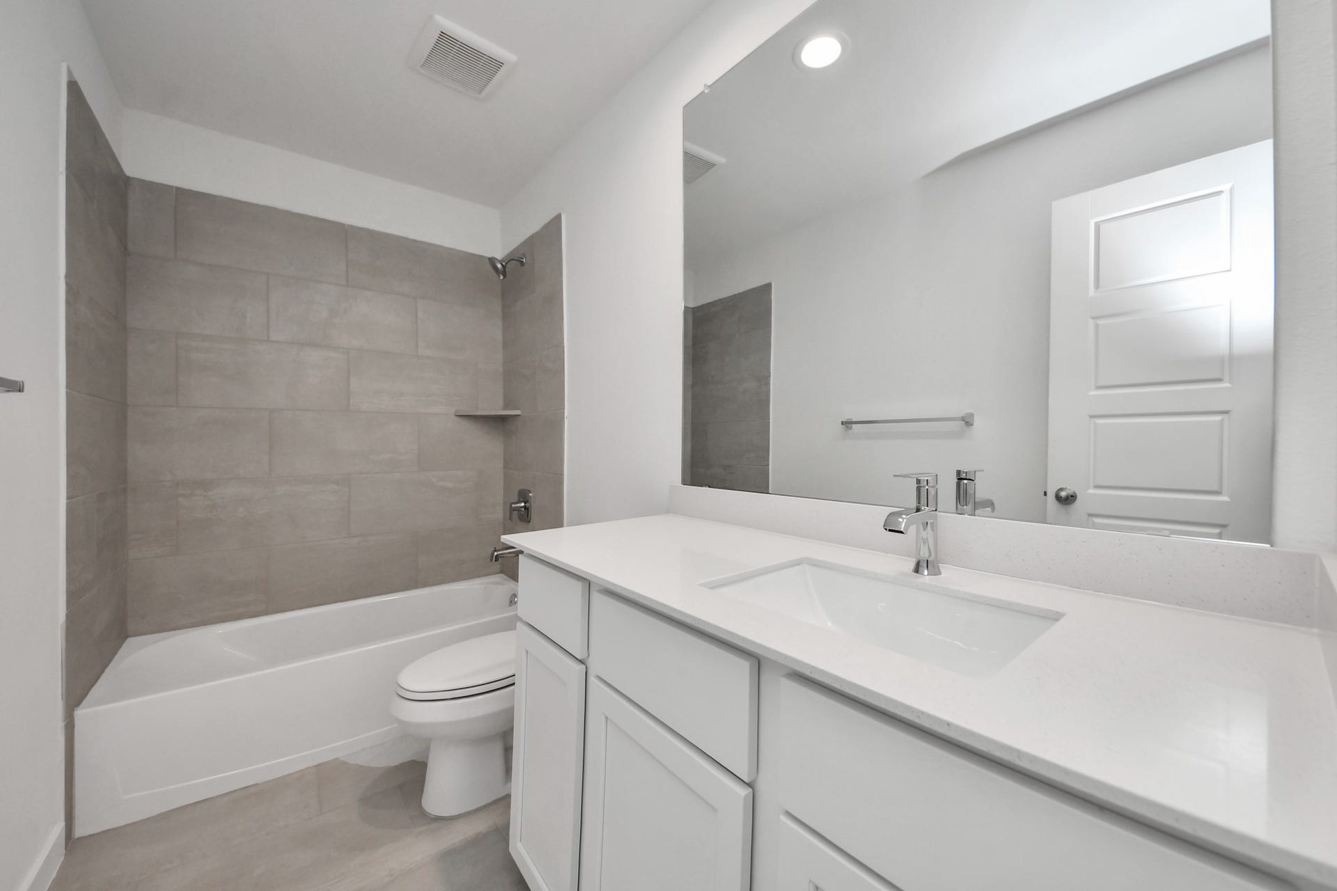 3072 Spoolwood Trail, Magnolia, TX 77355 Secondary bath features tile flooring, bath/shower combo with tile surround, light stained wood cabinets, beautiful light countertop.