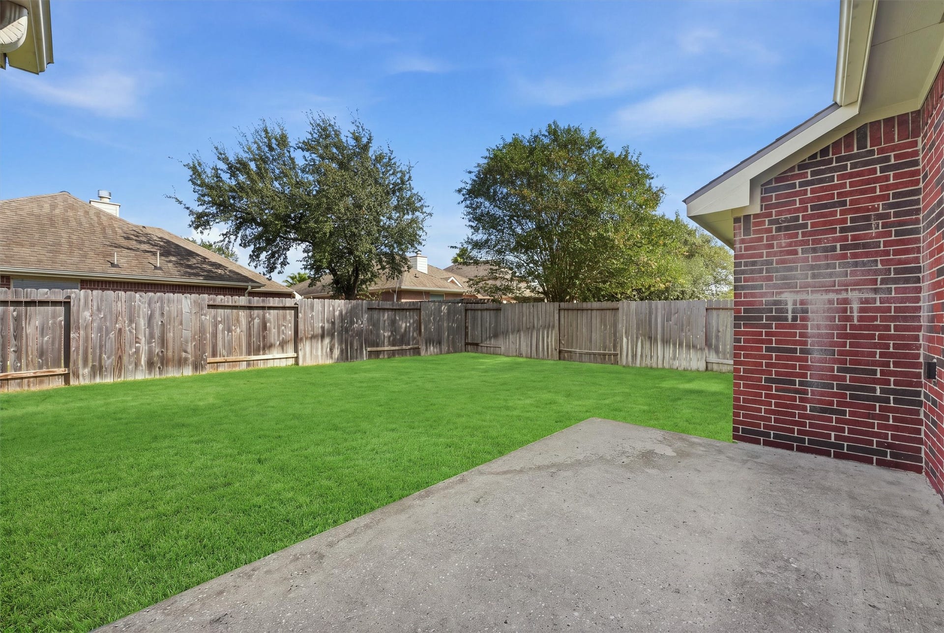 2426 Floral Ridge Drive, Spring, TX 77388 Spacious backyard with lush green lawn and a sturdy wooden fence, perfect for outdoor activities and privacy.