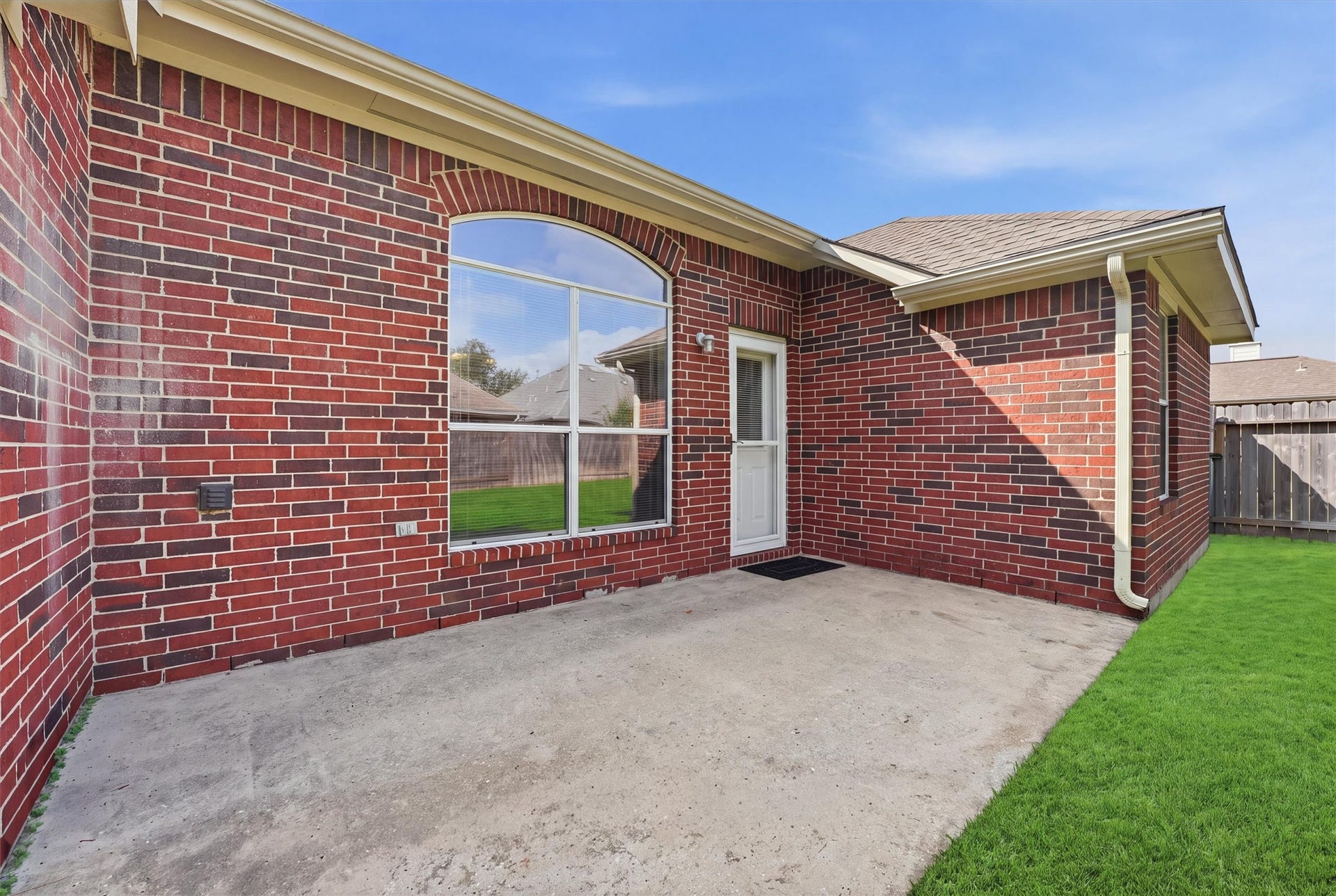 2426 Floral Ridge Drive, Spring, TX 77388 Charming red brick exterior with a spacious patio area, perfect for outdoor relaxation and entertaining.