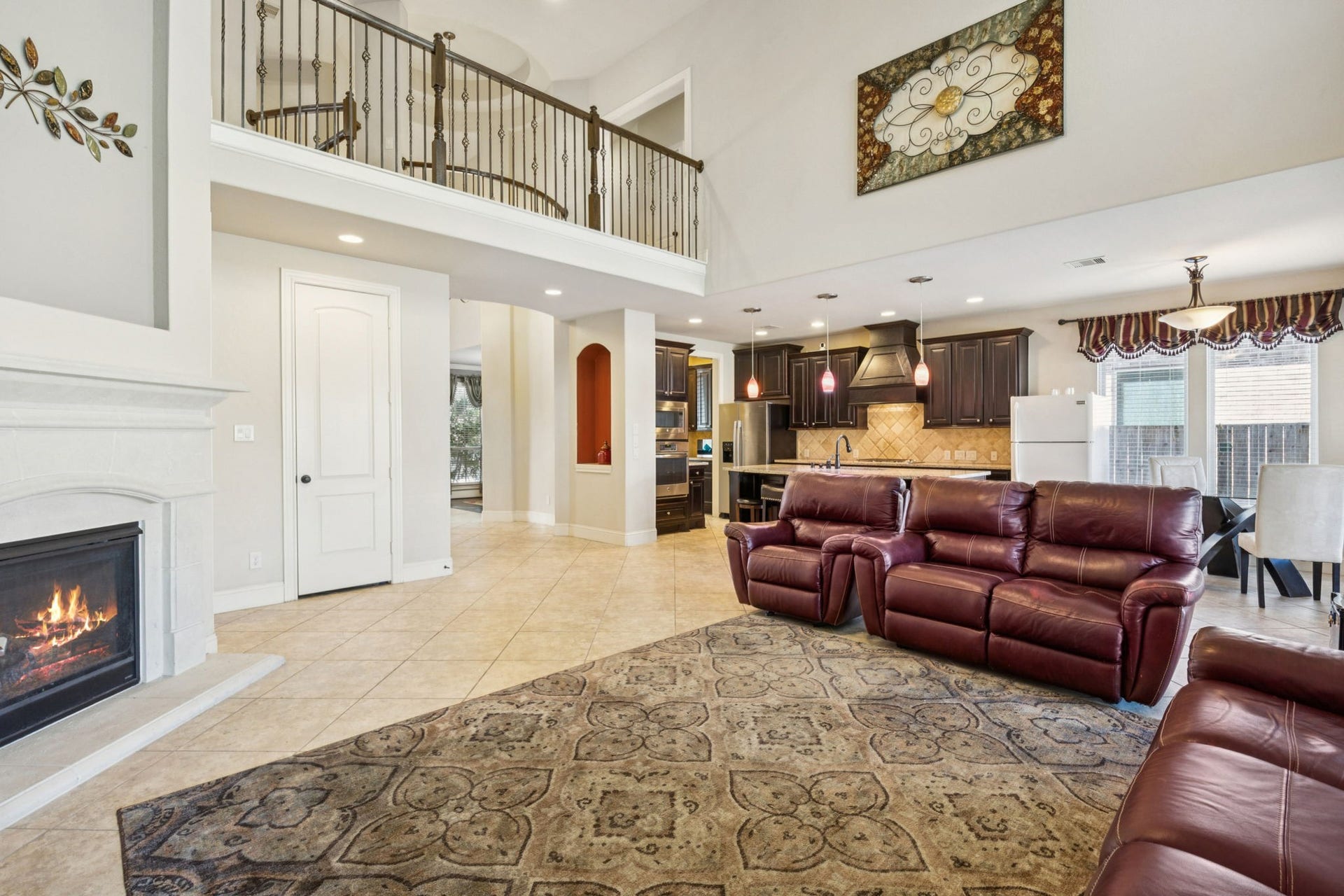 This expansive open-concept living area showcases soaring ceilings, a cozy fireplace, and seamless flow into the kitchenperfect for everyday living and entertaining alike. With generous space for multiple seating arrangements, this room offers flexibility to suit your lifestyle while keeping everyone connected.