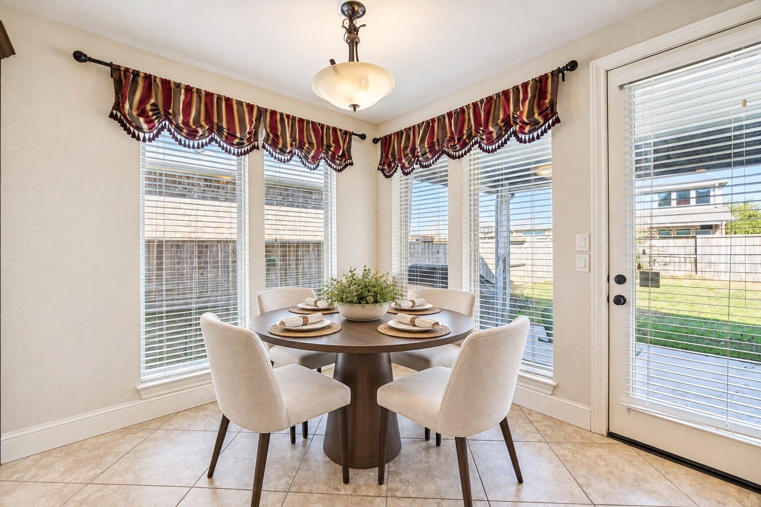 This light-filled breakfast nook, integrated into the open kitchen area, offers a wonderful setting for daily morning meals. This space has been virtually staged.