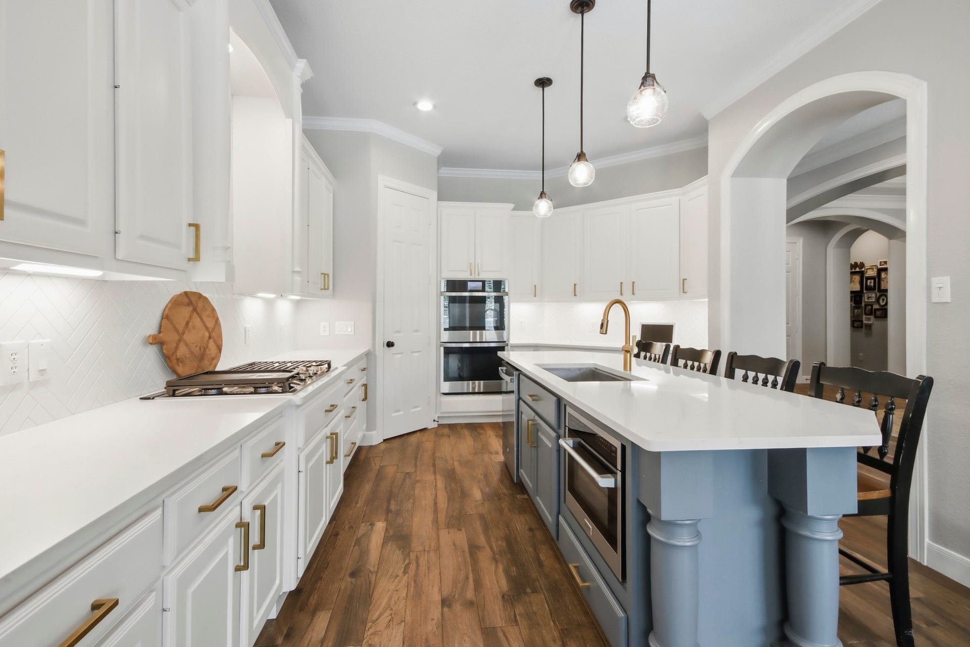 Updated kitchen featuring ample cabinetry and counterspace, a large island with room for seating, and sleek pendant lighting.