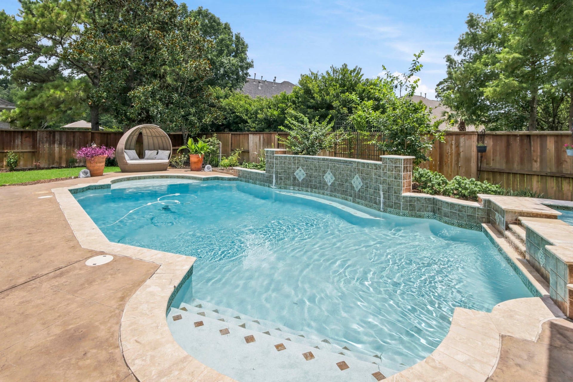 Outdoor kitchen with stainless steel grill, and mini fridge, set against a stylish stone backsplash and brick accents, perfect for entertaining.