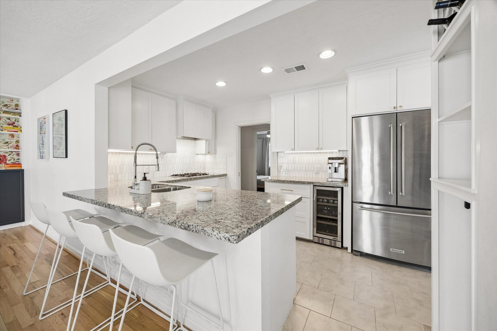 1232 Chantilly Lane, Houston, TX 77018 Updated kitchen features an oversized breakfast bar with seating, granite countertops, stainless steel appliances, a dedicated wine fridge, and extensive cabinetry for storage.