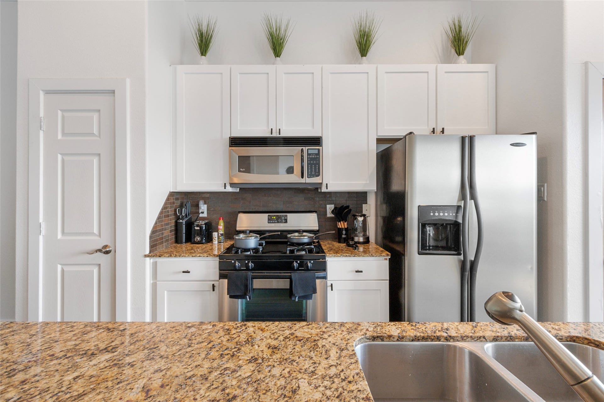 Kitchen with gas range, stainless refrigerator, and breakfast bar