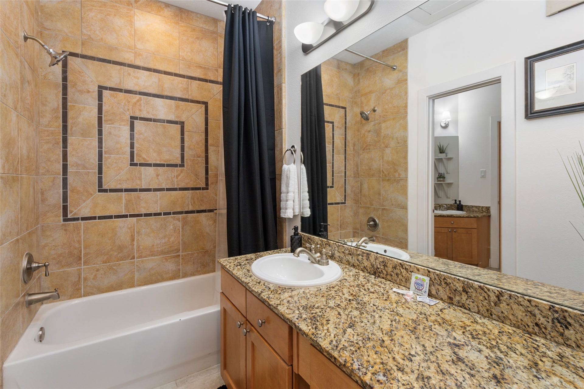 Full bath with granite vanity and tile surround tub
