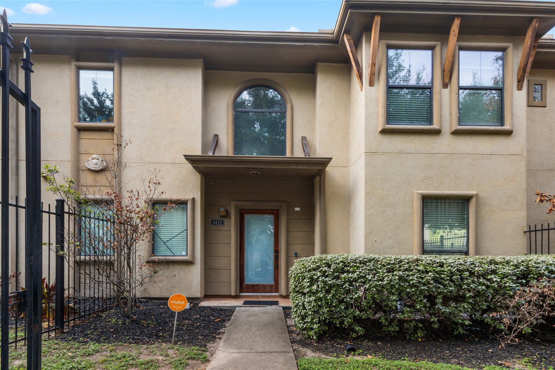 Gated townhome exterior with landscaped front entry