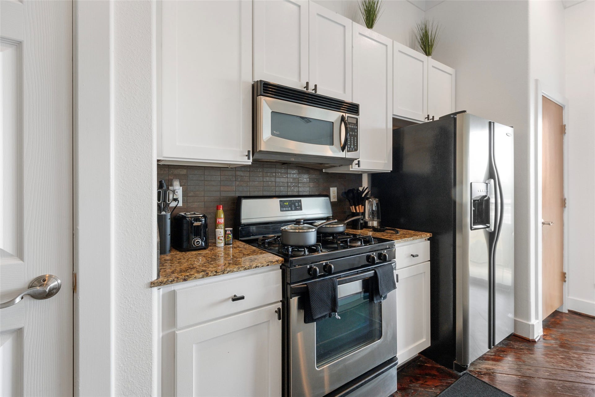 Kitchen with tall white cabinets and stainless steel appliances