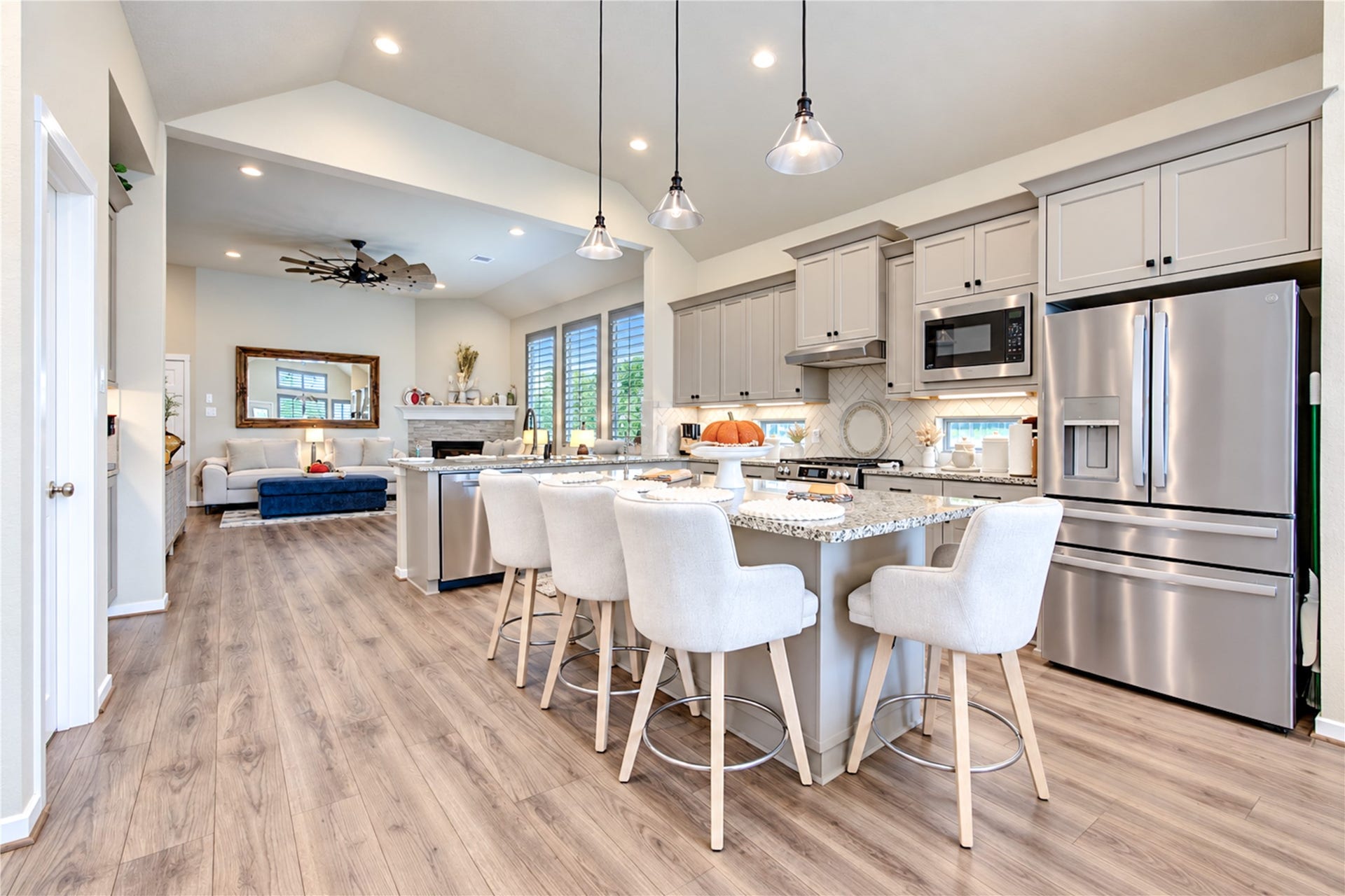 24911 Via Arabella Lane, Richmond, TX 77406 The open kitchen features generous counter space, a large island, shaker-style cabinetry and stainless steel appliances, all overlooking the family room.