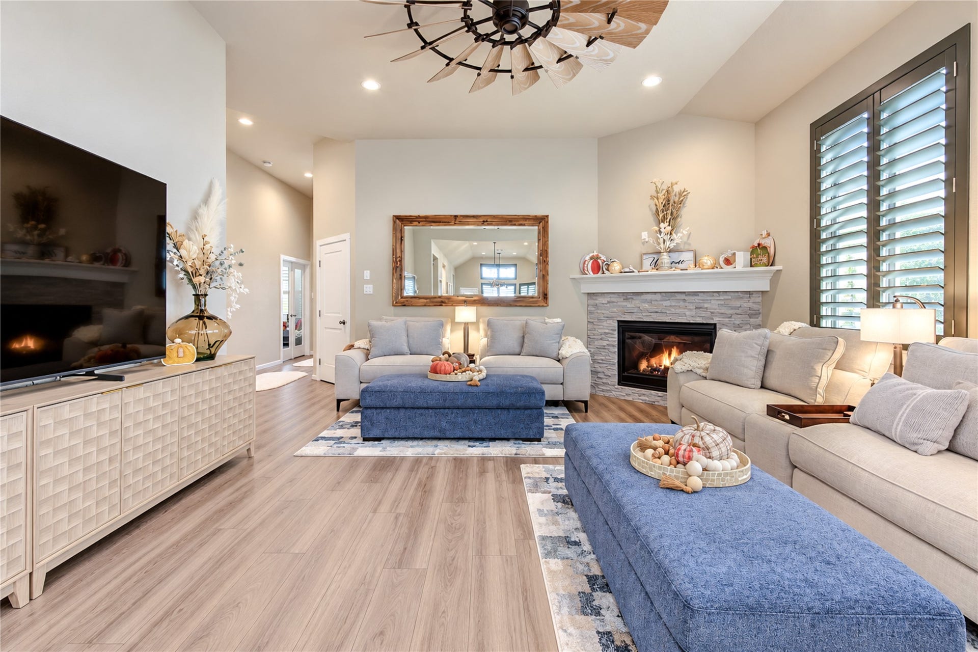24911 Via Arabella Lane, Richmond, TX 77406 A warm and inviting family room with high ceilings, a beautiful stone-accented fireplace and wood-look tile flooring.