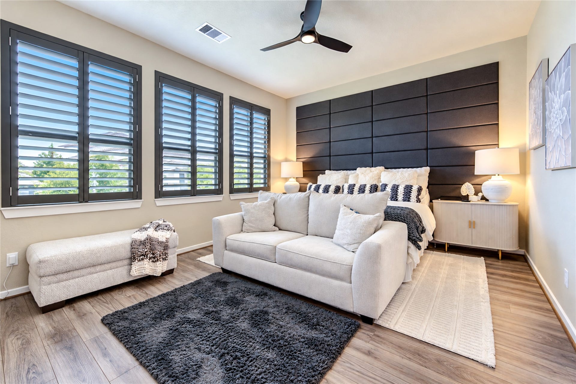 24911 Via Arabella Lane, Richmond, TX 77406 A spacious primary bedroom with wood-look tile flooring, plantation shutters and plenty of natural light.