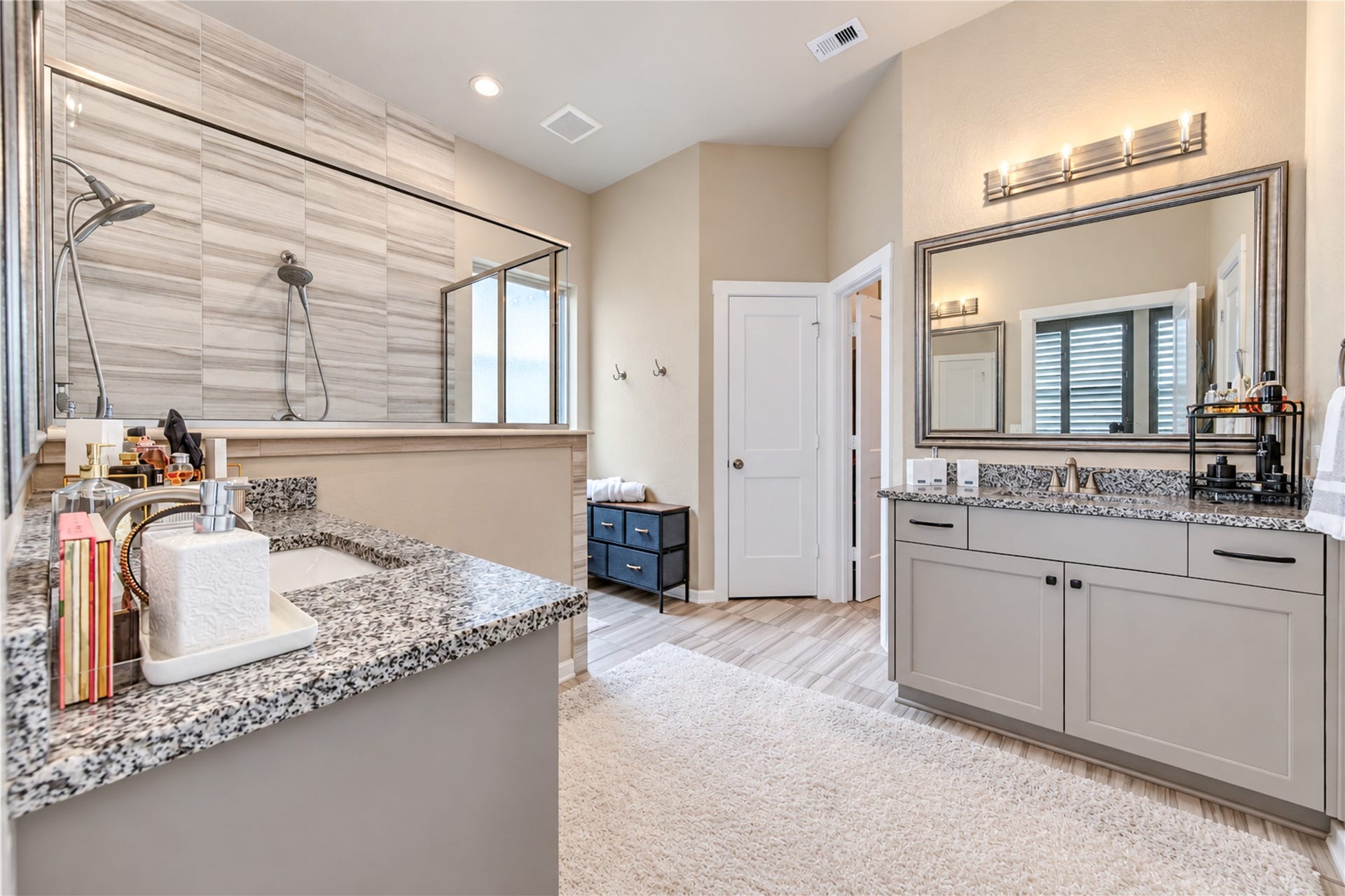24911 Via Arabella Lane, Richmond, TX 77406 A spacious primary bath featuring separate vanities, granite countertops and a beautifully tiled walk-in shower.