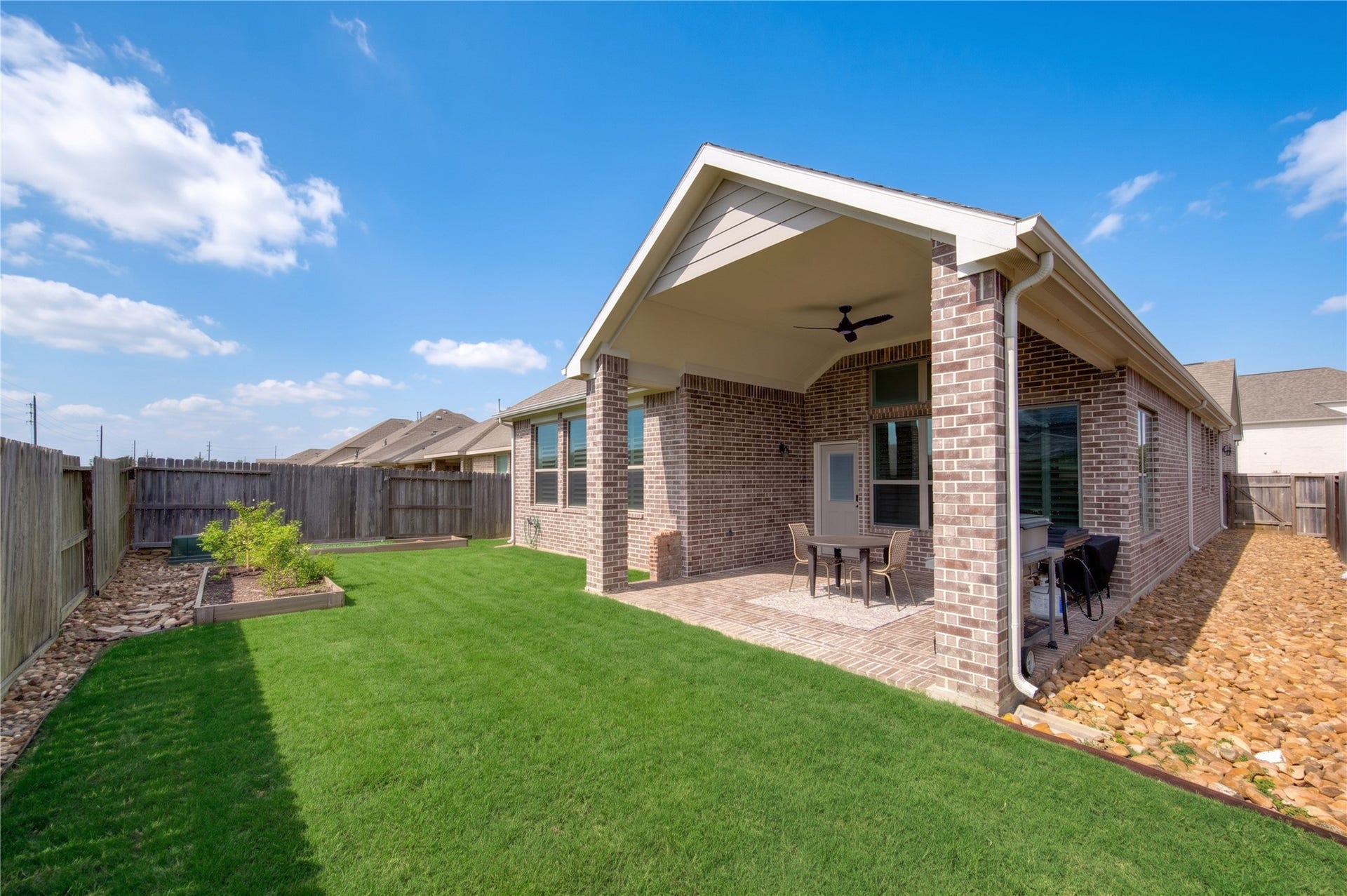 24911 Via Arabella Lane, Richmond, TX 77406 The backyard features a covered patio, green space and a nicely maintained rear exterior.