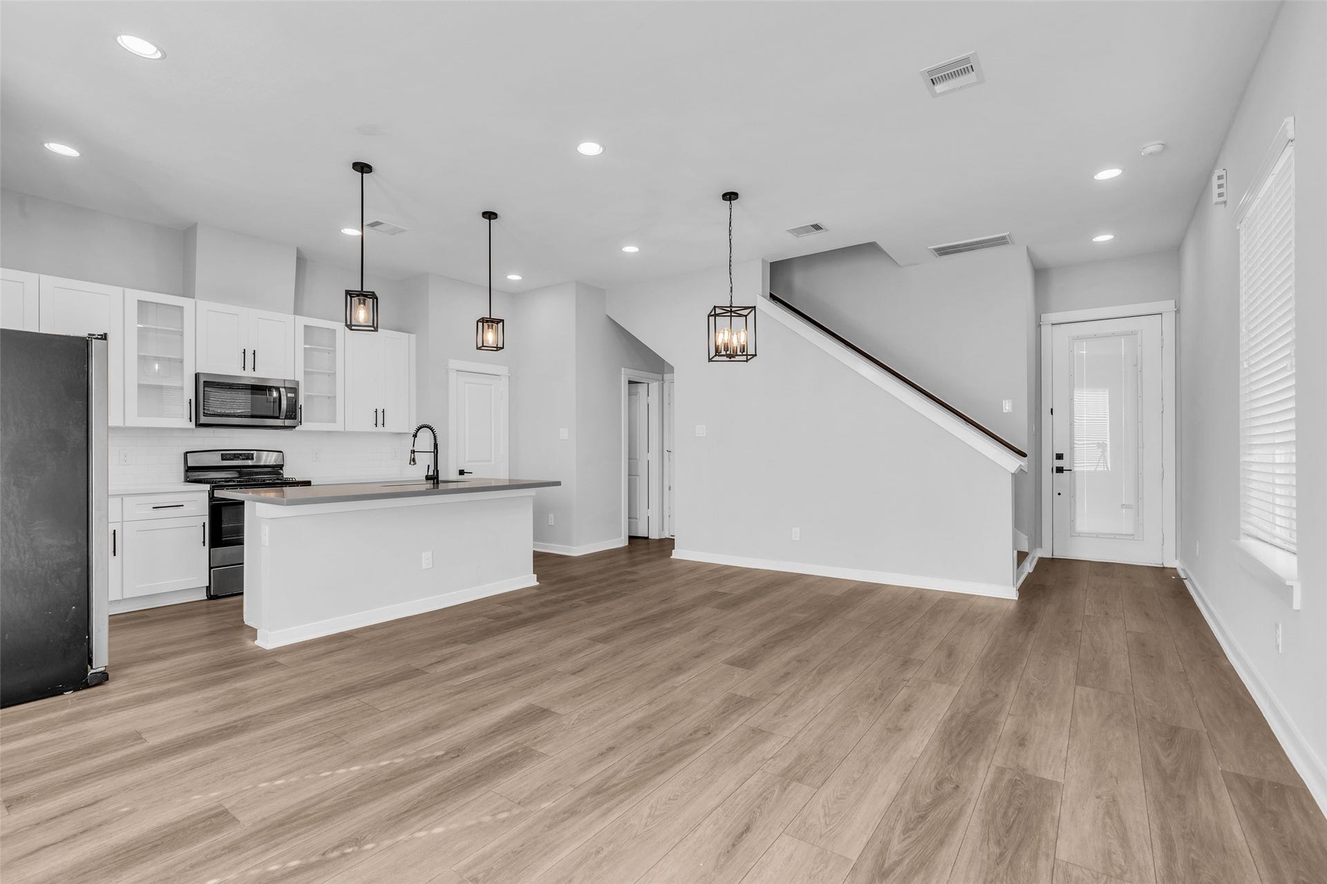 8474 Berry Green Lane, Houston, TX 77022 One open, light-filled layout made for hosting, from the living area to the kitchen island.
