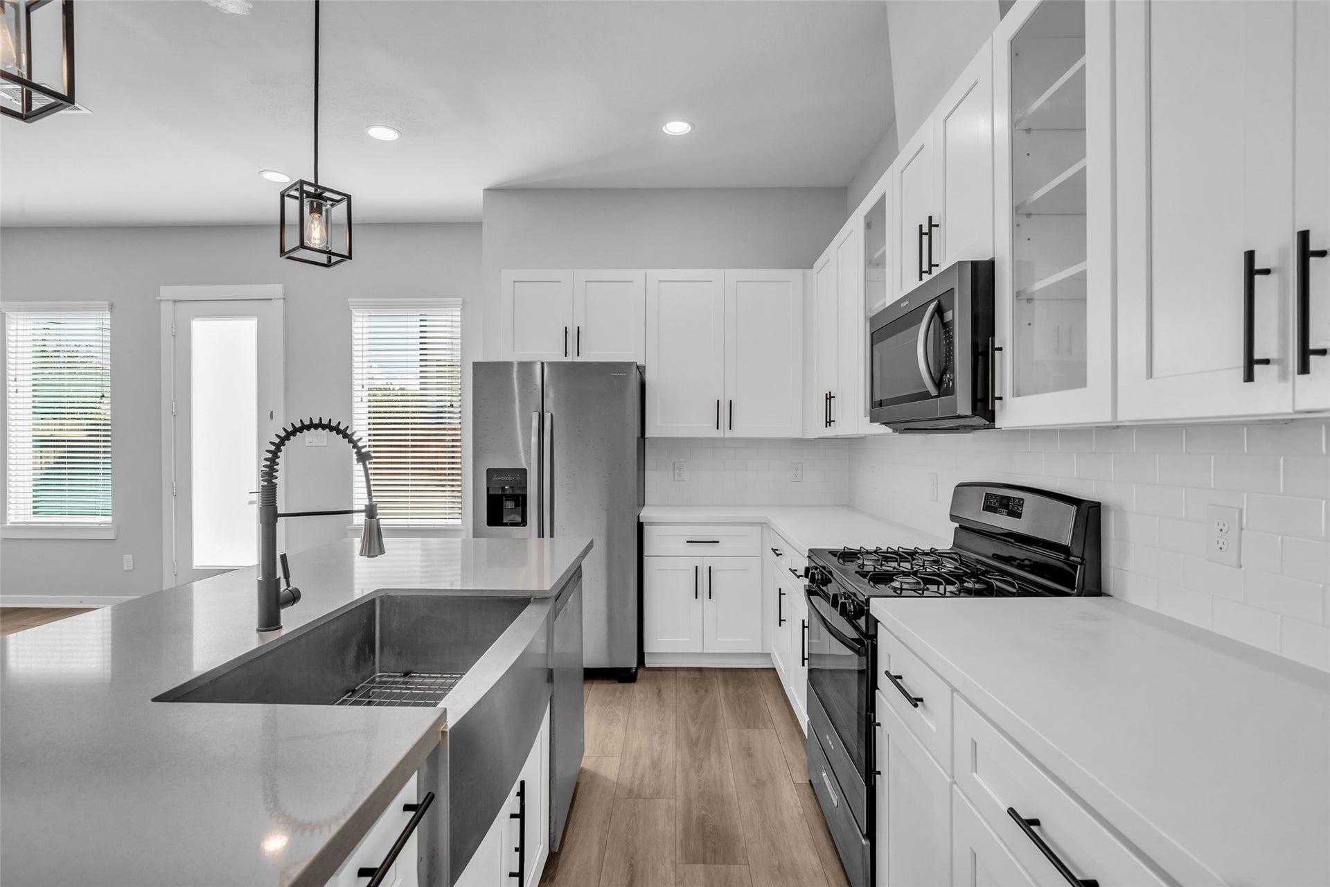 8474 Berry Green Lane, Houston, TX 77022 Details that make everyday cooking easier: a deep farmhouse sink, pull-down faucet and subway tile backsplash.