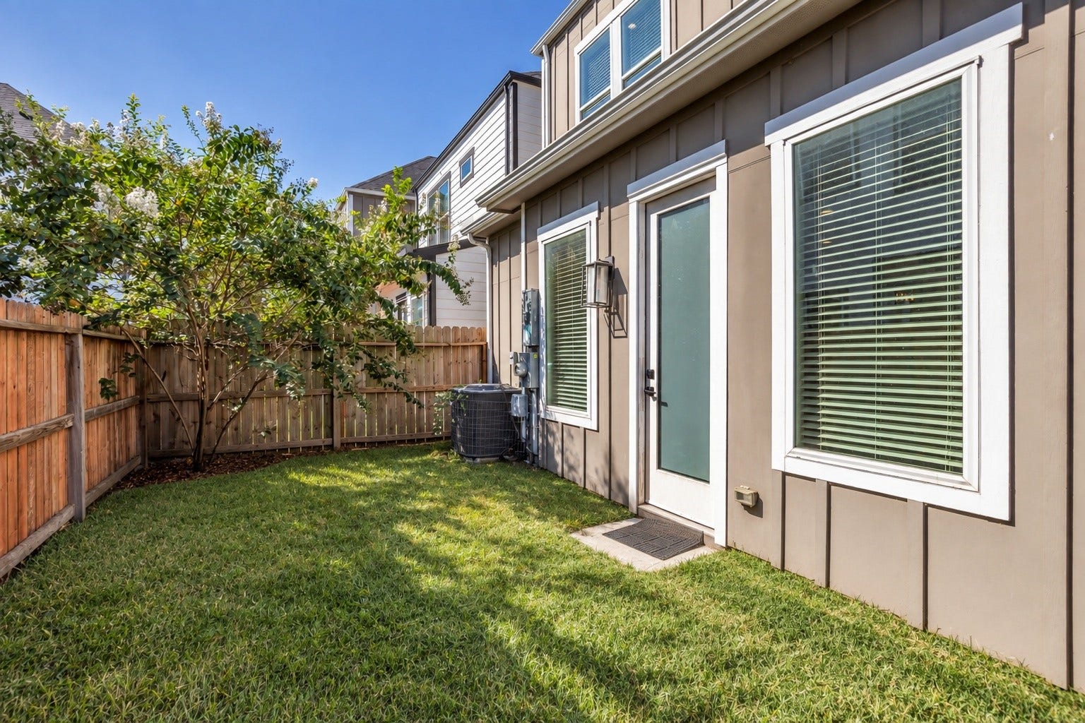 8474 Berry Green Lane, Houston, TX 77022 A private, fenced backyard shaded by a mature tree.