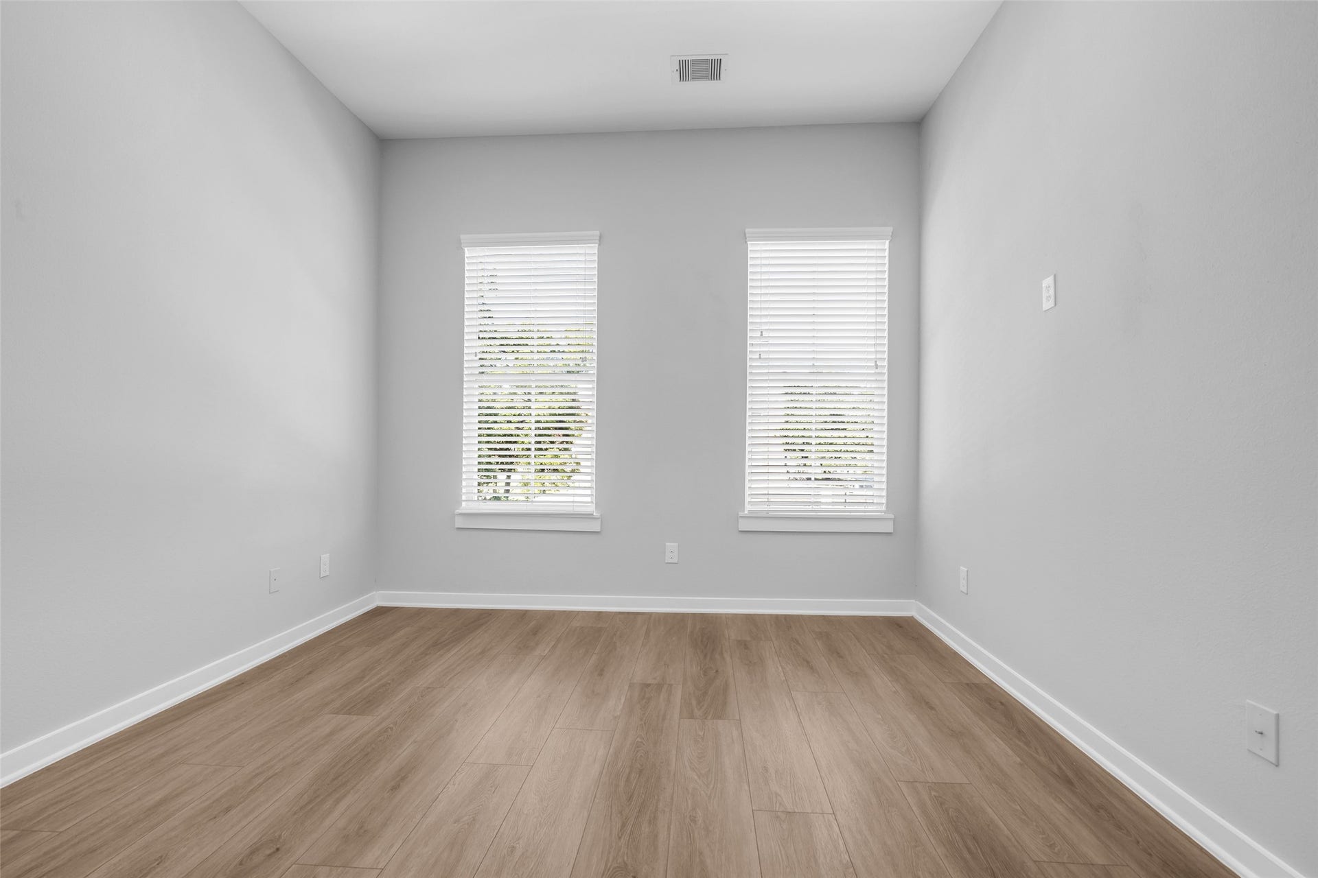 8474 Berry Green Lane, Houston, TX 77022 A bright secondary bedroom with two windows, ready for guests or a home office.