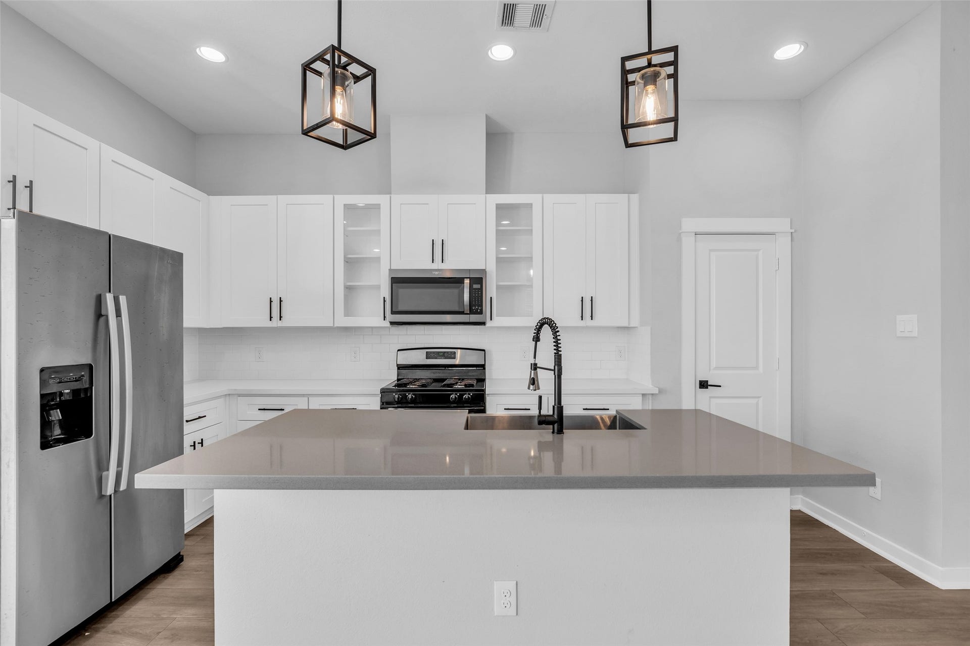 8474 Berry Green Lane, Houston, TX 77022 A cook's kitchen with a large center island, stainless steel appliances and plenty of white shaker cabinetry.