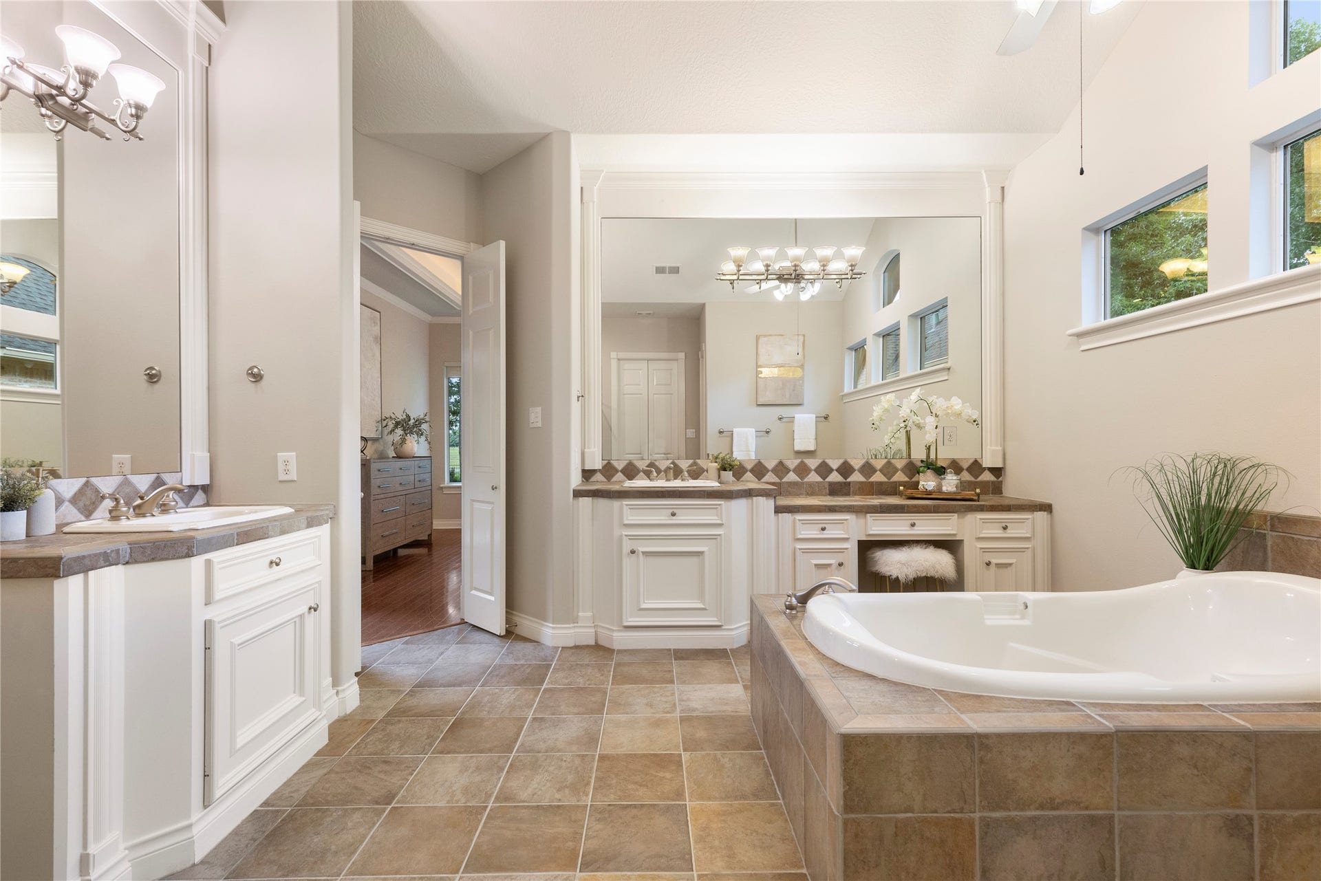 6207 Windrose Hollow Lane, Spring, TX 77379 The primary bath includes separate vanities, a jetted tub, and generous natural light. Its layout offers comfort, space, and a classic suite experience.