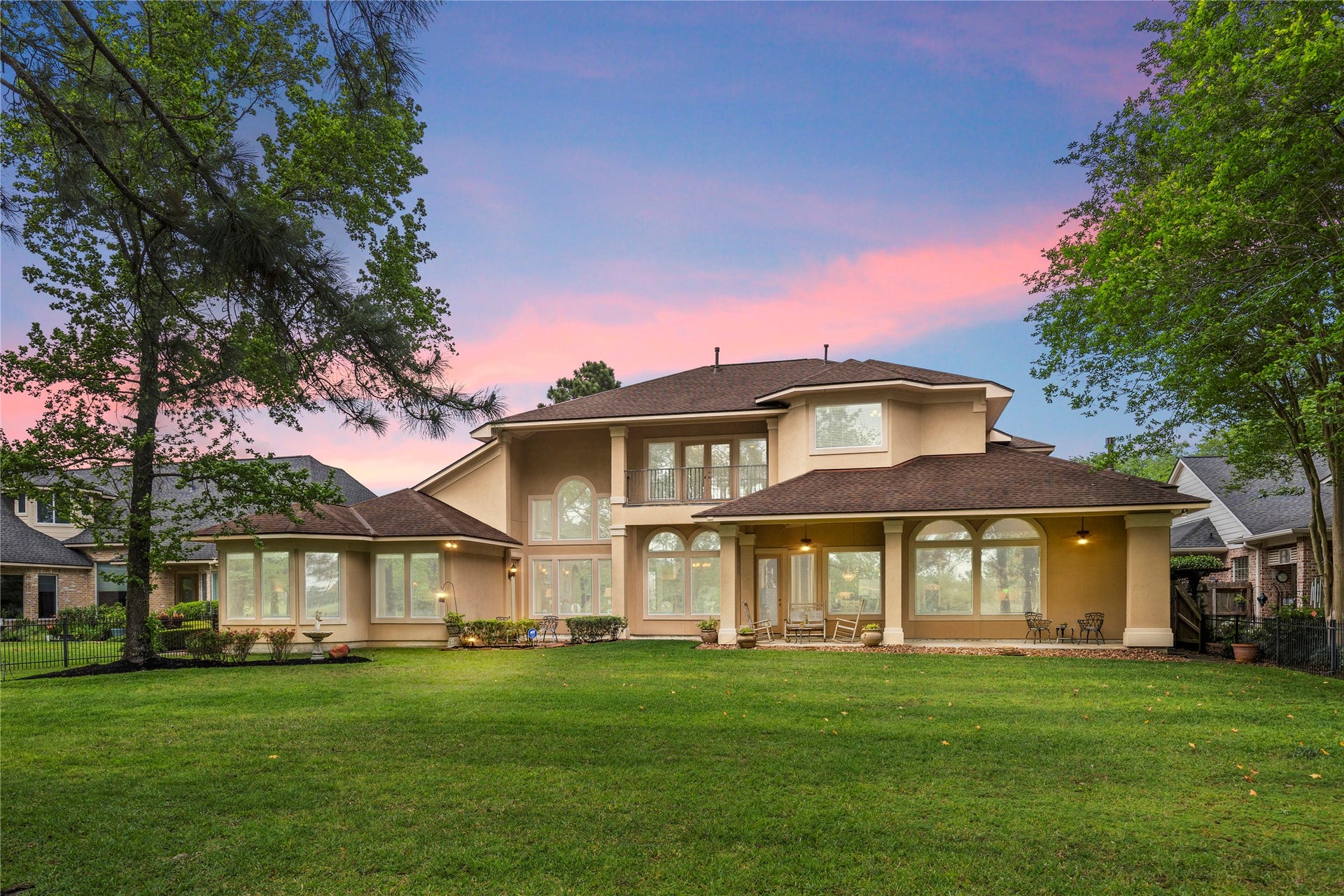 6207 Windrose Hollow Lane, Spring, TX 77379 At twilight, the rear of the home glows against the golf course backdrop, creating a warm and memorable impression. The covered patio and large yard make the property feel inviting for evening gatherings.