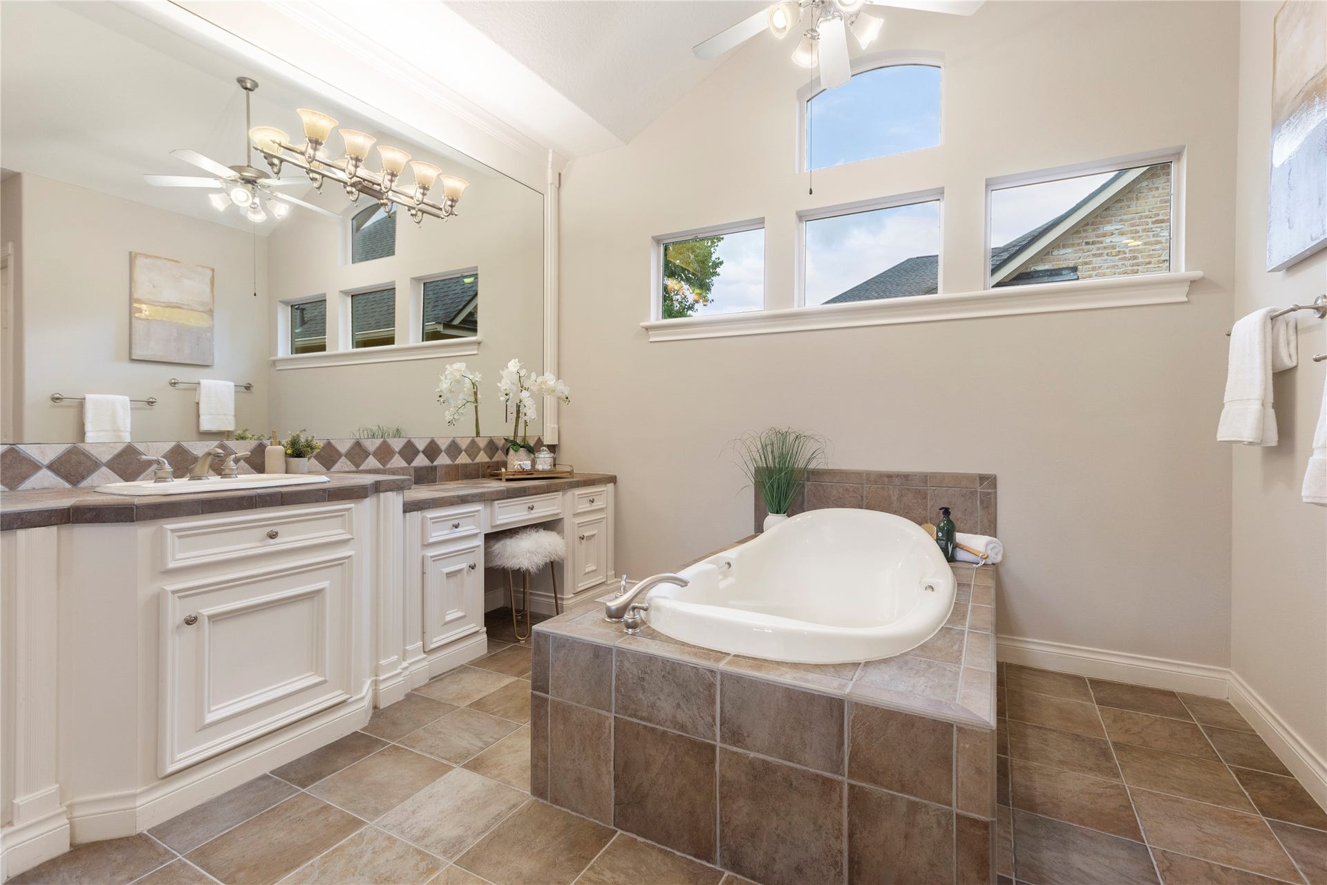 6207 Windrose Hollow Lane, Spring, TX 77379 The bathing area is framed by windows and a raised tub surround, creating a relaxing focal point within the suite. This space feels bright, spacious, and connected to the private setting outside.