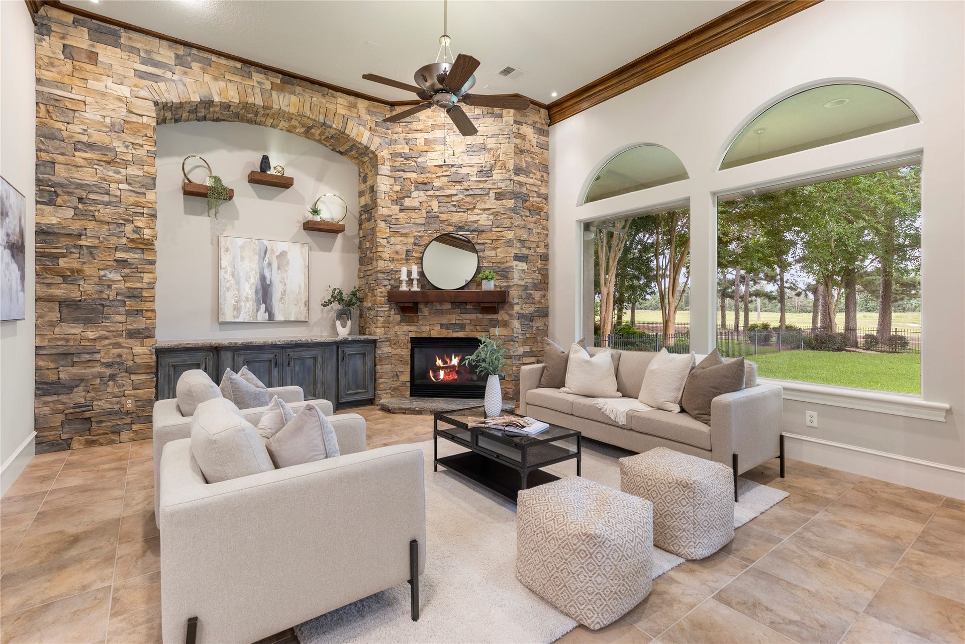6207 Windrose Hollow Lane, Spring, TX 77379 The den features a custom stone wall, quartzite hearth, lighted floating shelves, painted cabinetry, and a bespoke wood mantle. This remodel gives the room texture, warmth, and a strong architectural anchor.