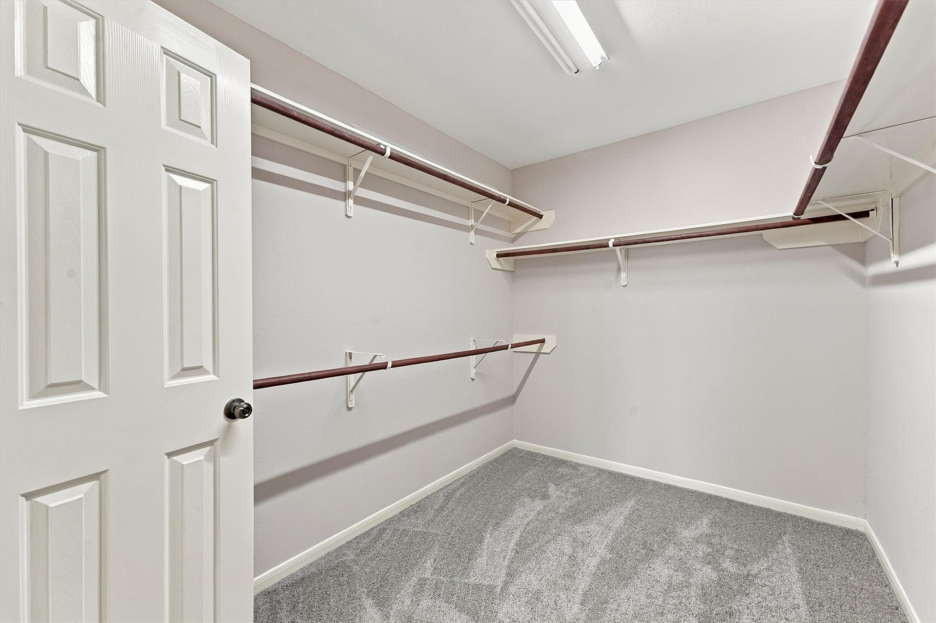 Spacious walk-in closet with ample shelving and hanging space, perfect for organized storage.