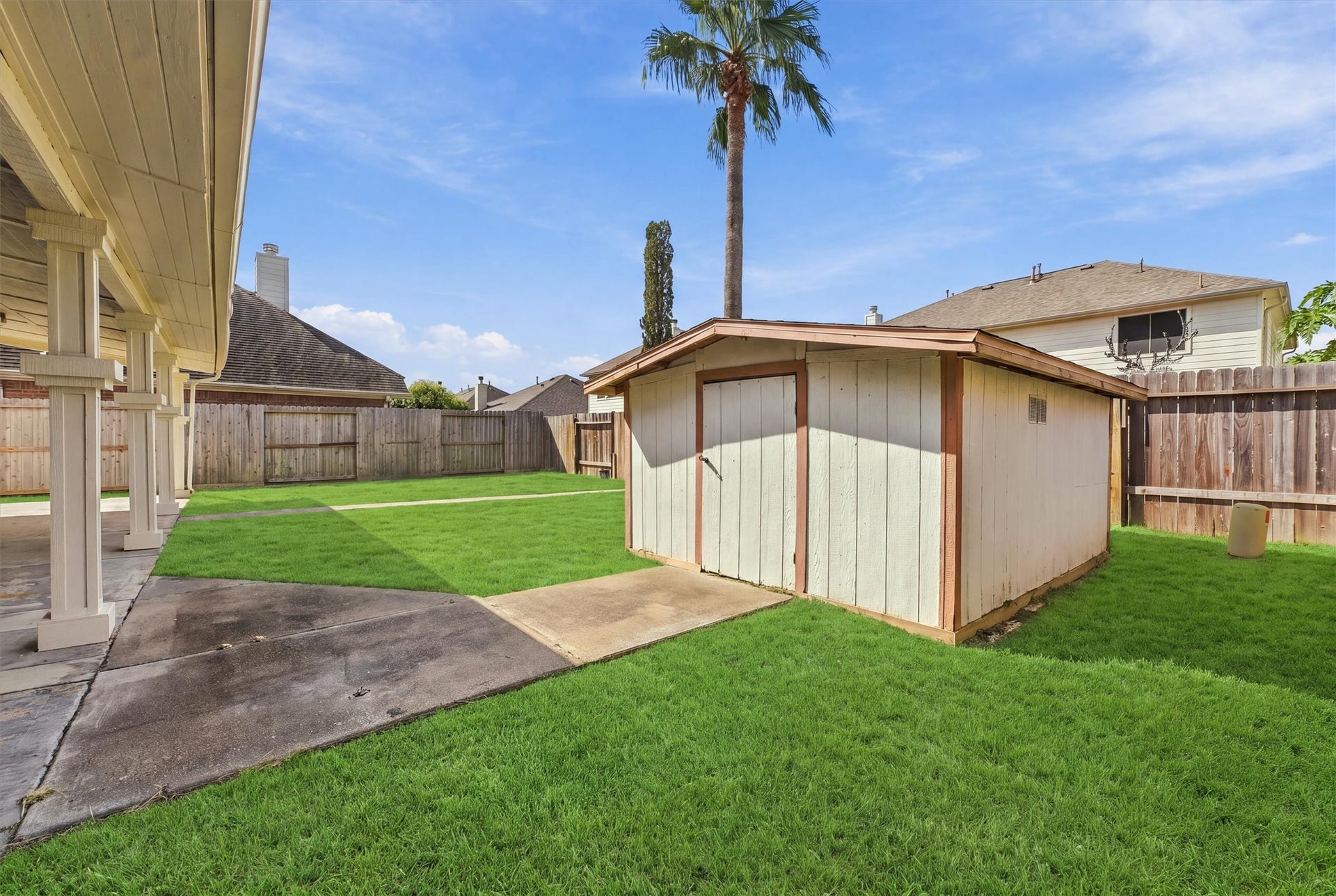 Discover the perfect blend of functionality and charm with this spacious outdoor shed, ideal for all your storage needs, nestled in a beautifully manicured backyard.
