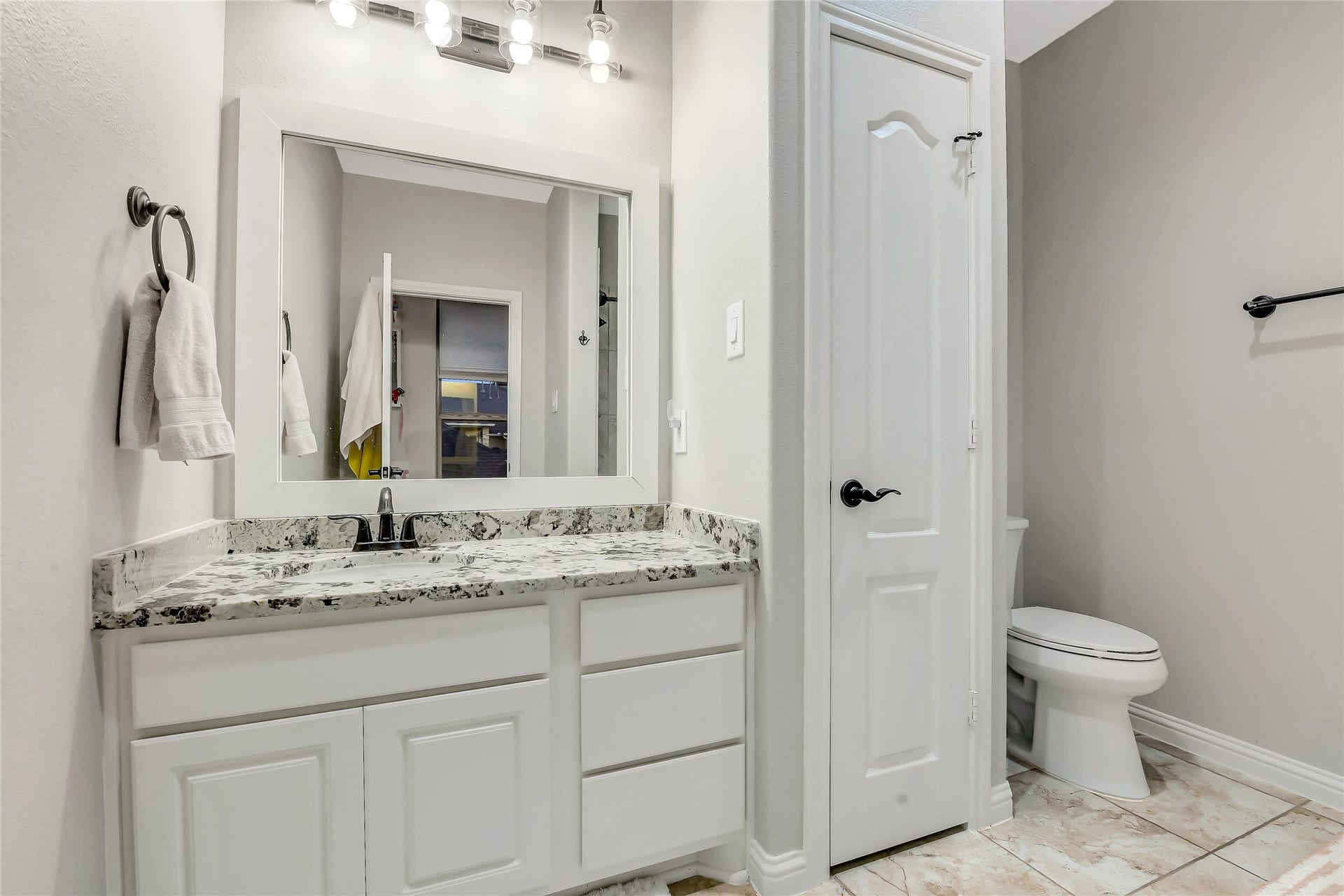 5410 Briarcliff Lane, Fulshear, TX 77441 Bright ensuite bathroom with a granite vanity, tile floors, and convenient linen storage.