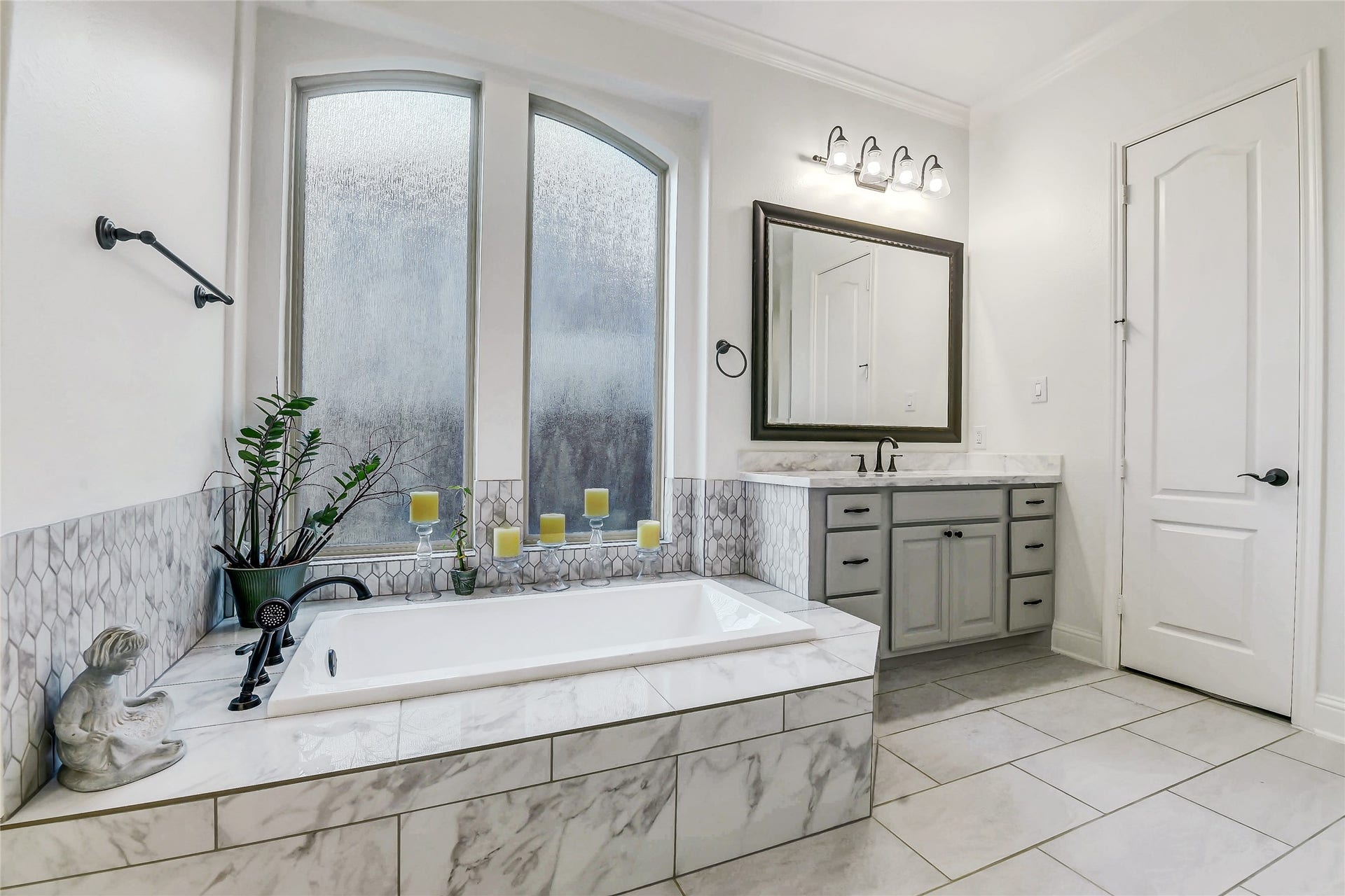 5410 Briarcliff Lane, Fulshear, TX 77441 Luxurious soaking tub creates the perfect retreat with elegant tile surround and oversized arched windows.