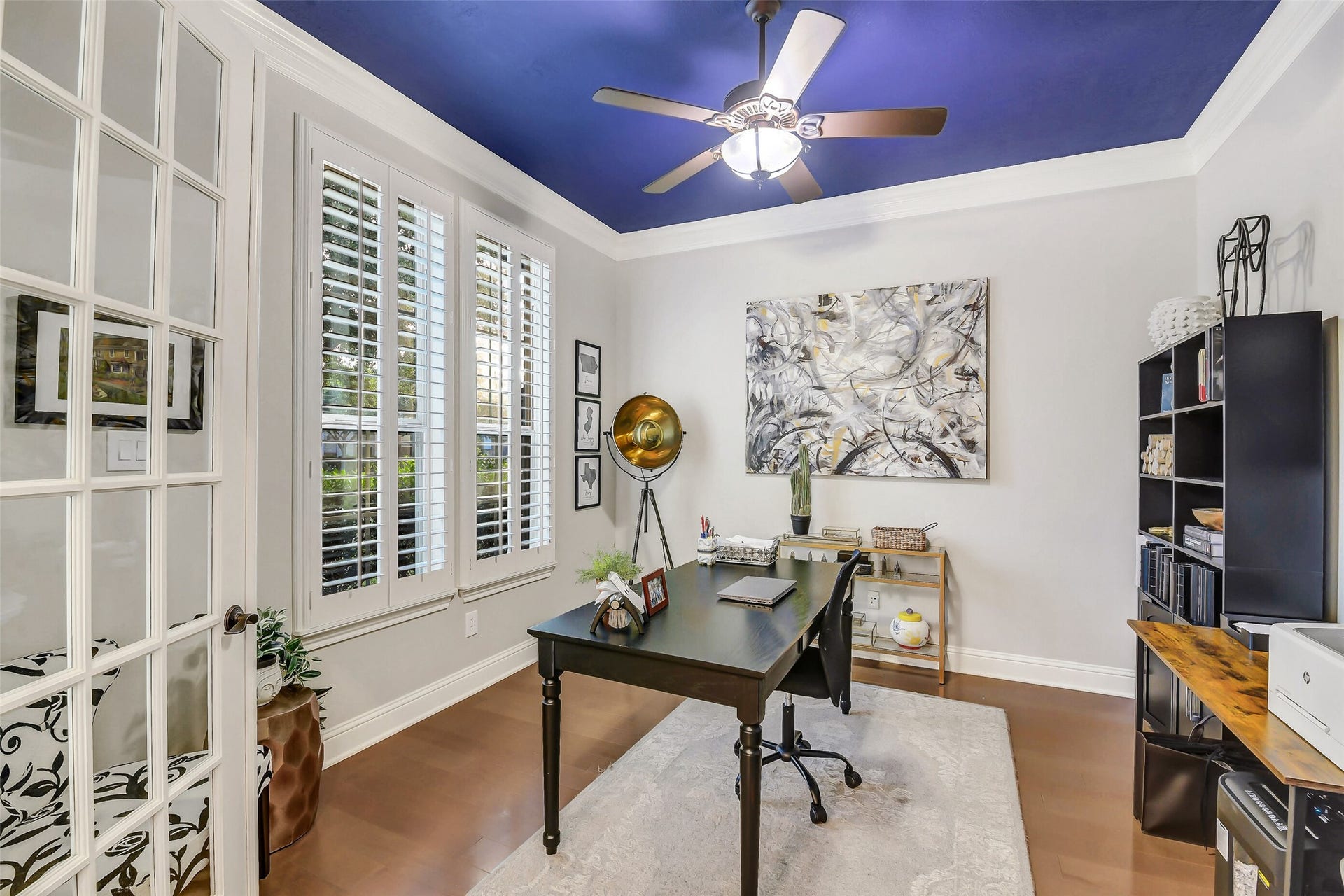 5410 Briarcliff Lane, Fulshear, TX 77441 Light-filled private study enclosed by French doors, featuring plantation shutters, hardwood flooring, and an ideal layout for a home office or quiet workspace.