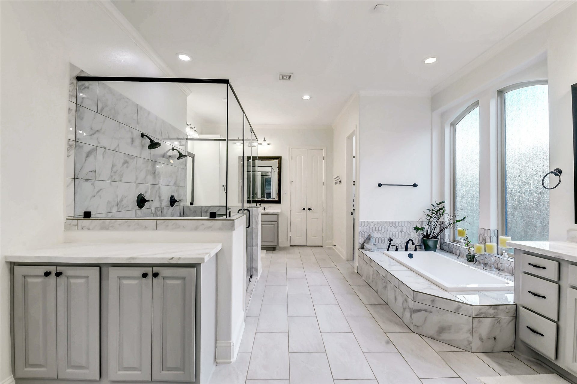 5410 Briarcliff Lane, Fulshear, TX 77441 Indulge in a spa-inspired primary bath featuring separate vanities with dual sinks, an oversized walk-in shower with dual showerheads, and a luxurious soaking tub perfectly positioned for relaxation. Thoughtfully designed with a dedicated vanity area and separate his-and-her walk-in closets, this elegant retreat offers exceptional comfort, functionality, and abundant storage.