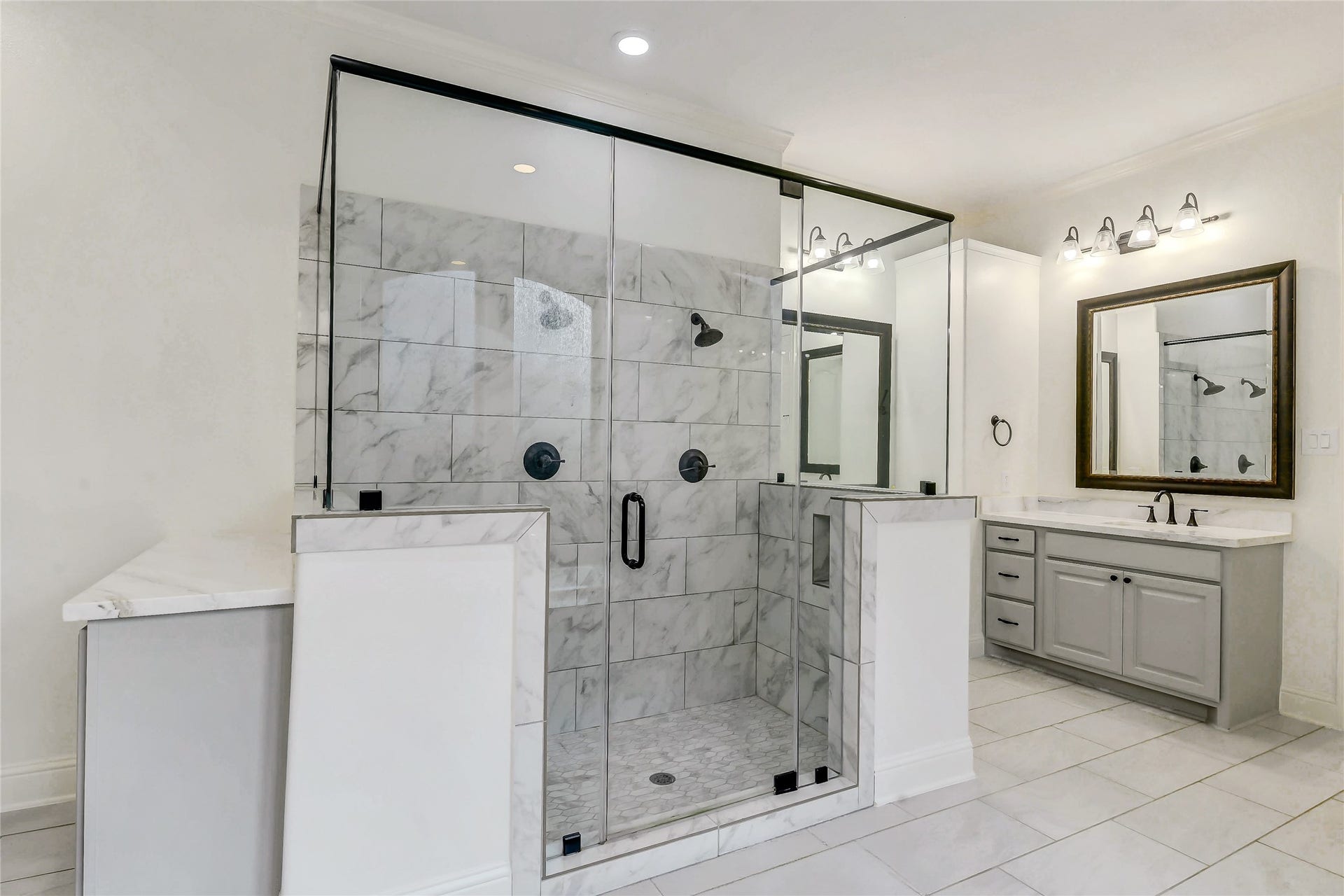 5410 Briarcliff Lane, Fulshear, TX 77441 Elegant primary bathroom featuring a large walk-in shower with dual showerheads, two separate sink areas along with a separate vanity area and private water closet.