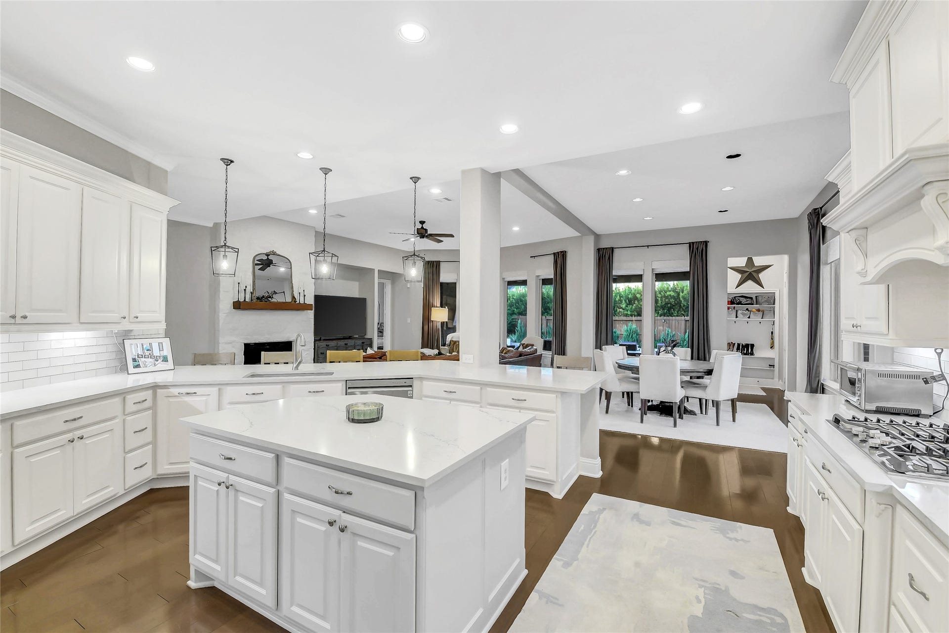 5410 Briarcliff Lane, Fulshear, TX 77441 The chef-inspired kitchen showcases crisp white cabinetry, sleek countertops, built-in stainless steel GE cafe appliances, a large breakfast bar and a center island that serves as the heart of the home. Thoughtfully designed with extensive workspace, under-cabinet lighting, and an airy layout, it blends style and functionality for effortless cooking and gathering.