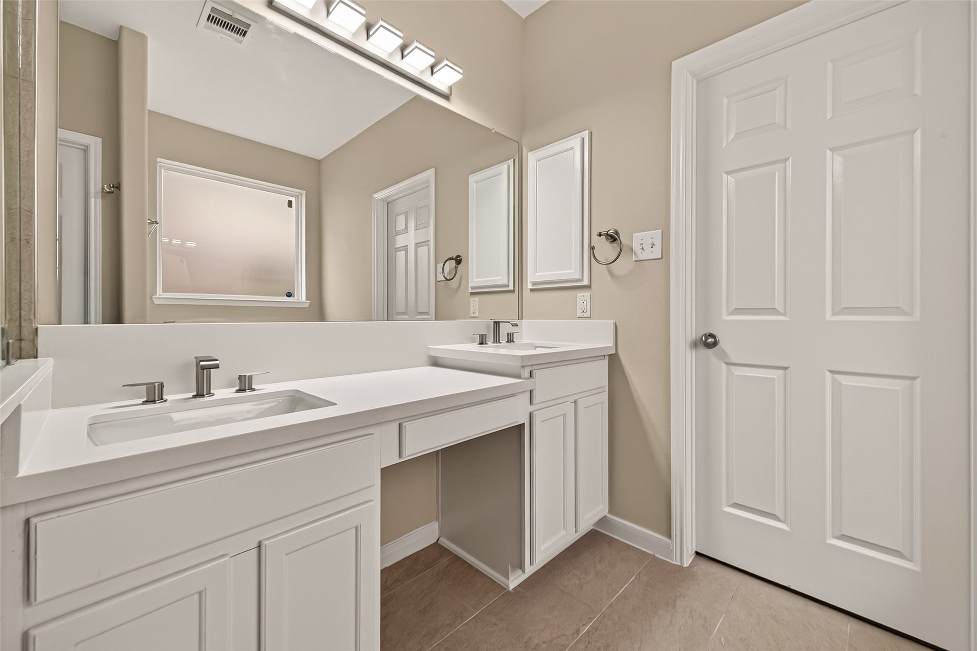 3635 Cottage Manor Lane, Katy, TX 77494 Split dual vanities with quartz-look countertops, brushed-nickel faucets, a seated makeup area, and a large mirror.