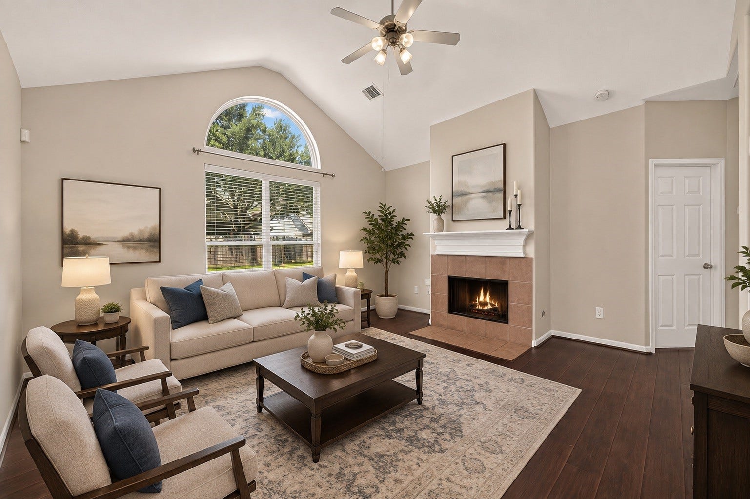3635 Cottage Manor Lane, Katy, TX 77494 Vaulted ceiling, arched transom window overlooking the backyard, and a tiled fireplace with a white mantel make this living room the heart of the home. (Virtually Staged)