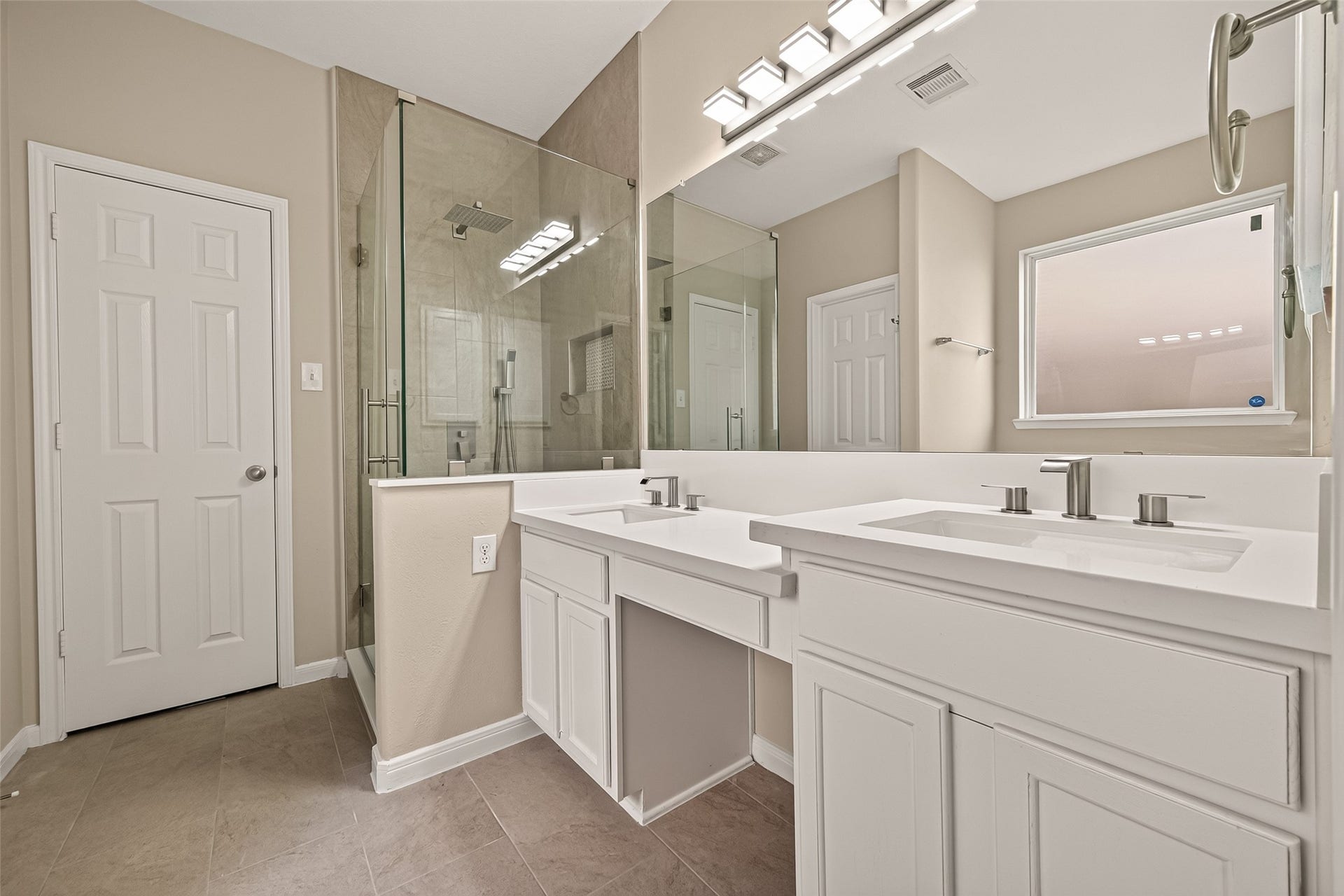 3635 Cottage Manor Lane, Katy, TX 77494 Updated primary bath with a frameless glass shower, rain showerhead, handheld wand, dual sinks, a makeup vanity, and modern light fixtures.