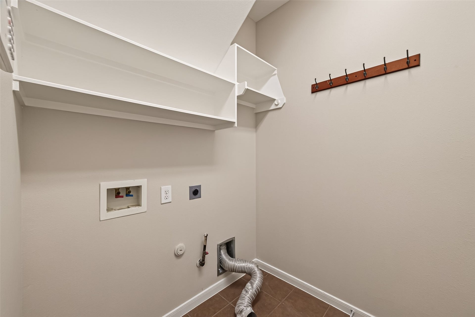 3635 Cottage Manor Lane, Katy, TX 77494 Dedicated utility room with built-in shelving, a coat hook rail, washer connections, and both gas and electric dryer hookups.