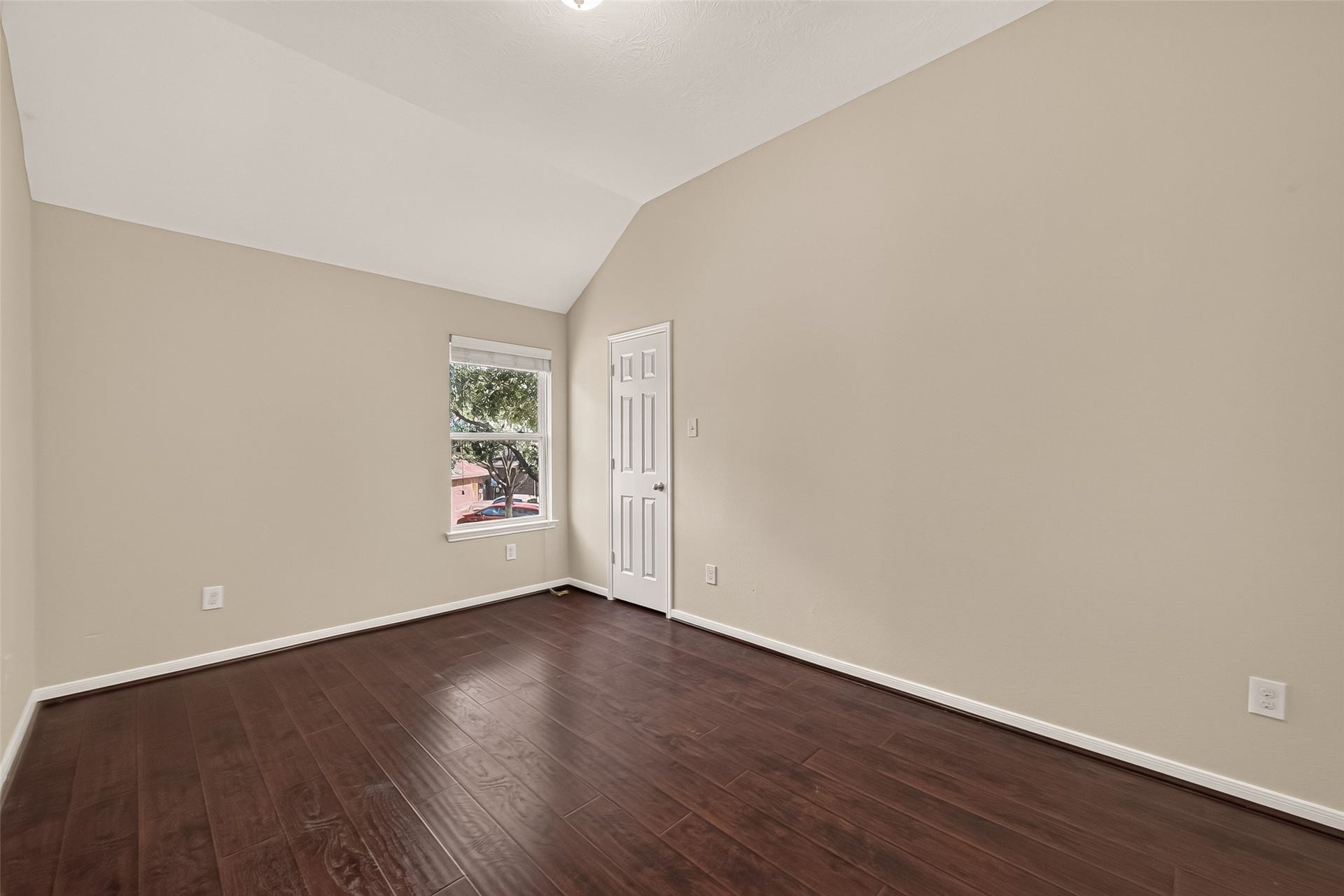 3635 Cottage Manor Lane, Katy, TX 77494 Bright bedroom with a vaulted ceiling, a tree-lined view out the window, and a walk-in closet.