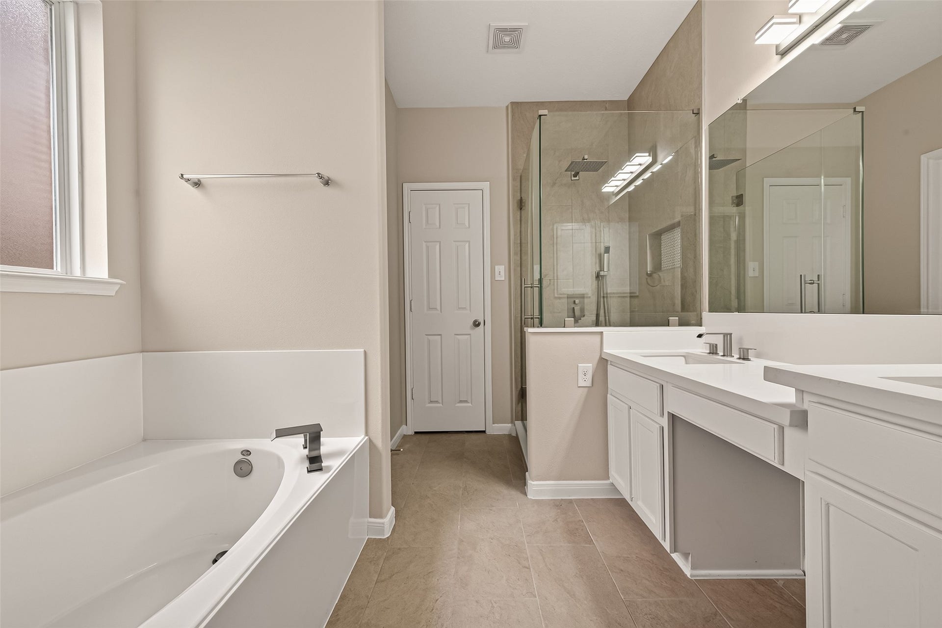 3635 Cottage Manor Lane, Katy, TX 77494 Garden soaking tub beneath a privacy window, alongside the walk-in shower and double vanity.