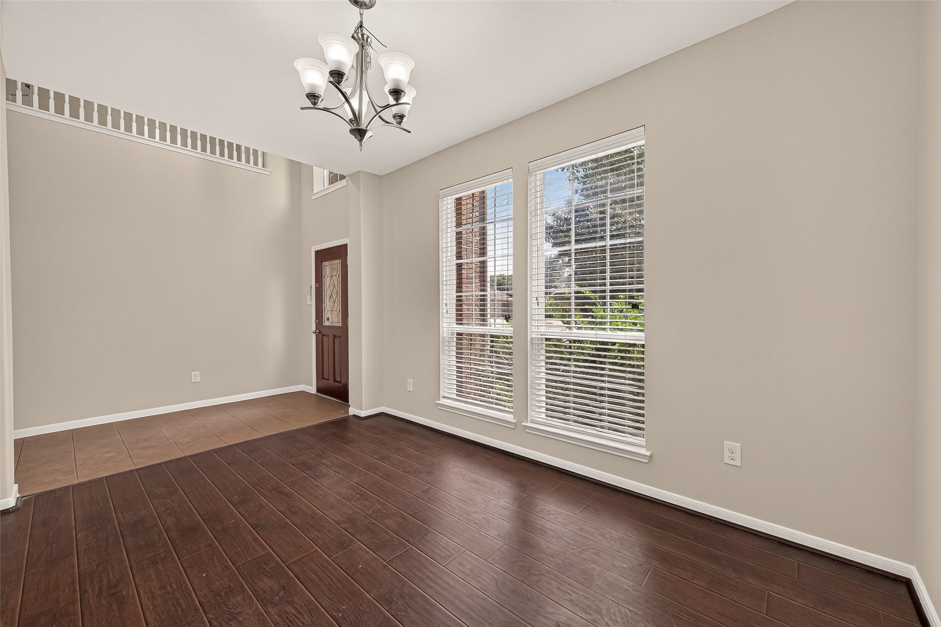 3635 Cottage Manor Lane, Katy, TX 77494 Formal dining room with a chandelier, tall windows, and a view back to the front entry and overlook above.