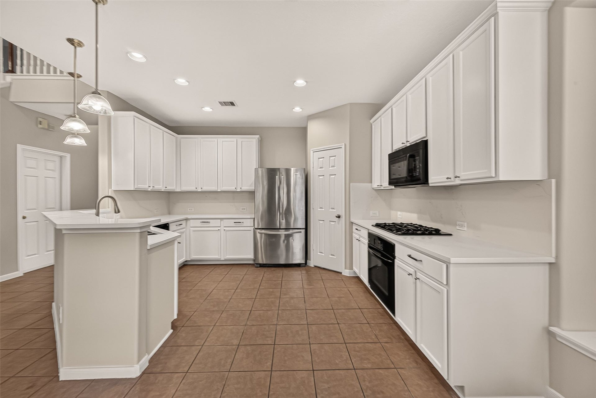 3635 Cottage Manor Lane, Katy, TX 77494 NEW & IMPROVED Kitchen!
Generous cabinet storage and counter space highlight this kitchen, complete with a built-in oven, gas cooktop, and microwave. Recessed lighting, a coordinating backsplash, and warm tile flooring complement the white cabinetry.