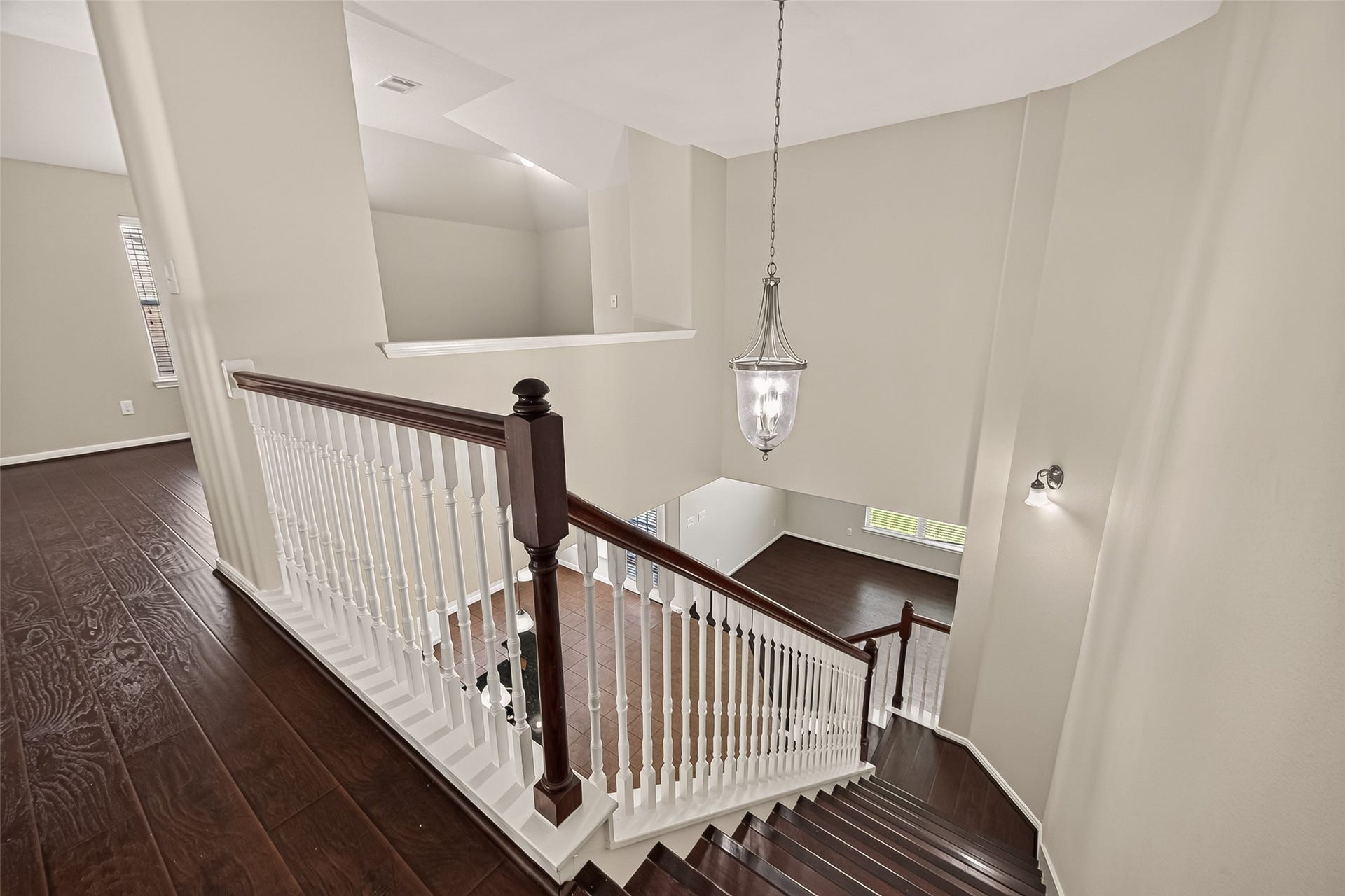 3635 Cottage Manor Lane, Katy, TX 77494 View from the top of the stairs into the two-story foyer with a lantern pendant, stained handrails, and white spindles.