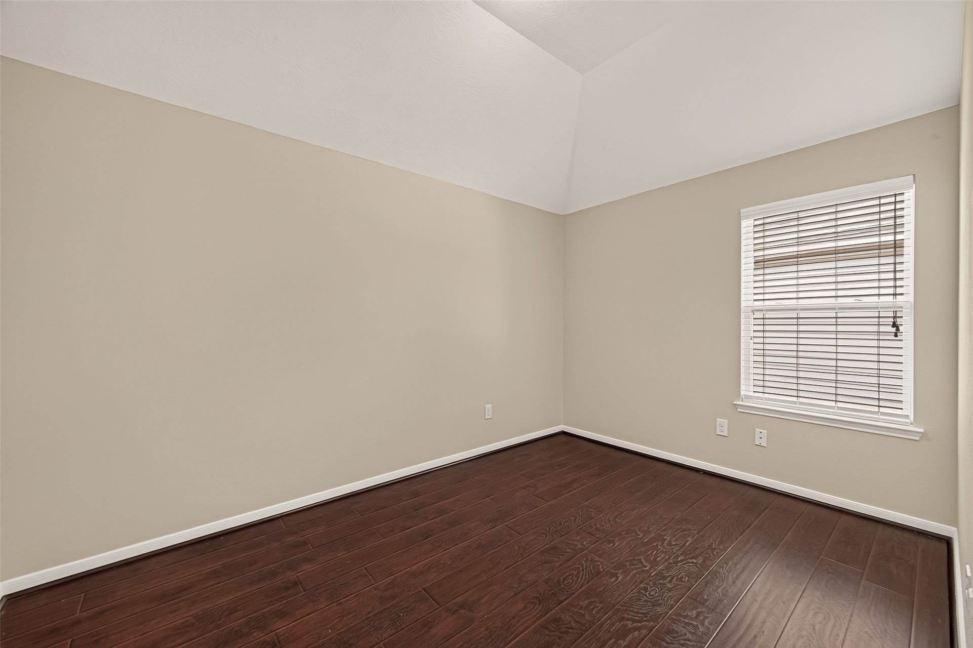 3635 Cottage Manor Lane, Katy, TX 77494 Bedroom with a vaulted ceiling, rich wood-look flooring, neutral paint, and a window with blinds.