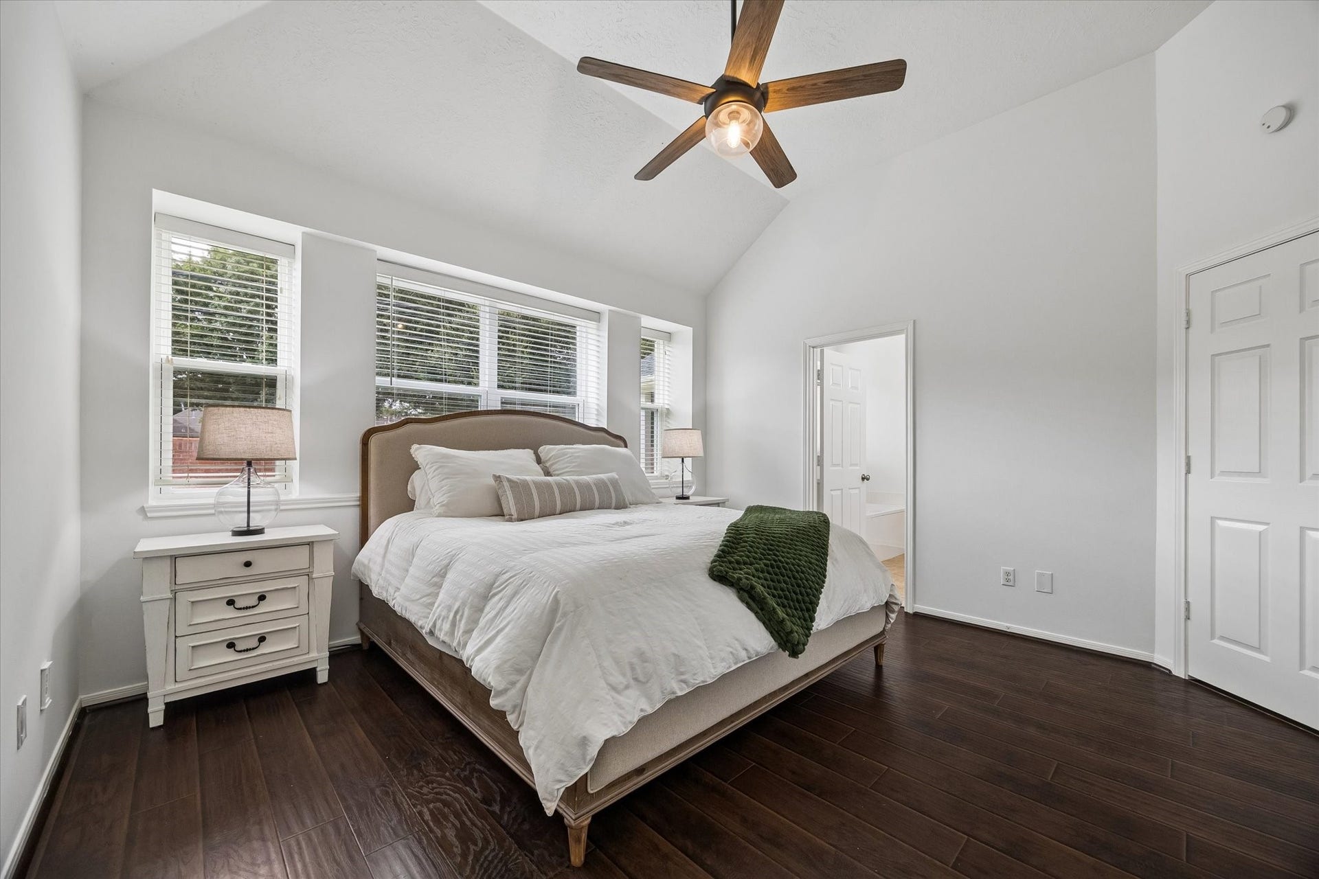 Spacious primary bedroom with vaulted ceiling, beautiful natural light and new windows installed in 2026.
