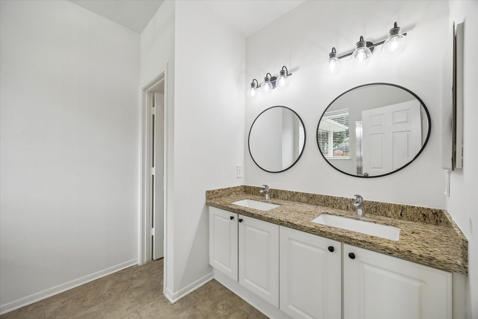 Primary bath features a spacious vanity with dual sinks and generous counter space.