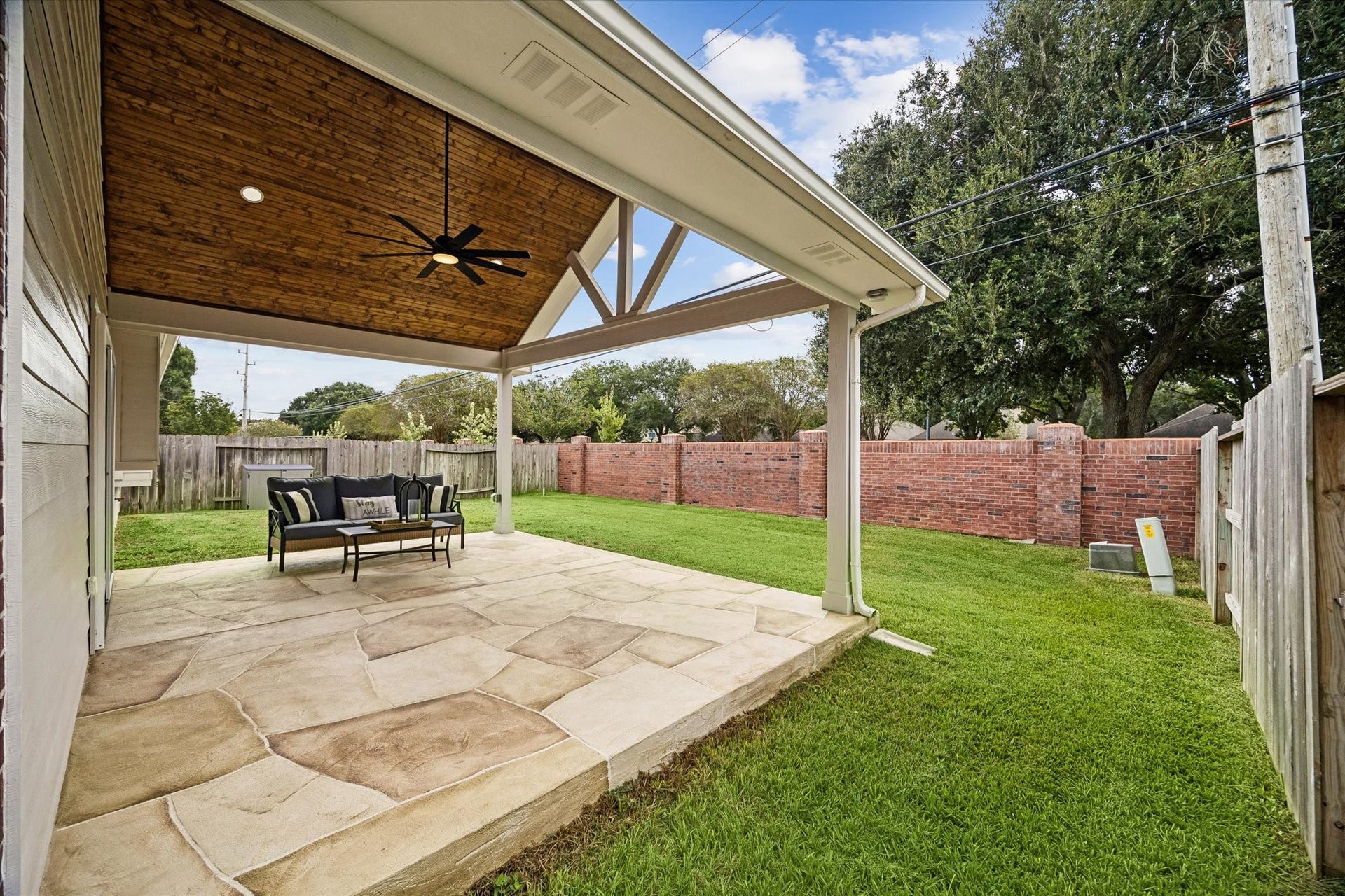 Another view of the new covered patio and backyard, offering plenty of room to enjoy the outdoors year-round.