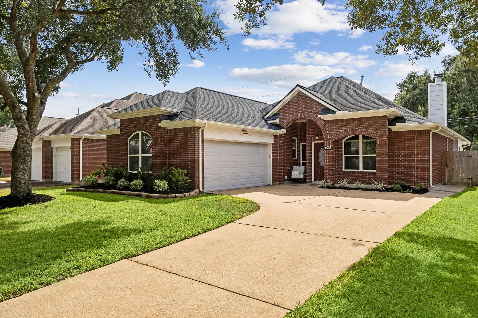 Another look at the home's beautiful exterior, mature trees and well-kept front lawn.