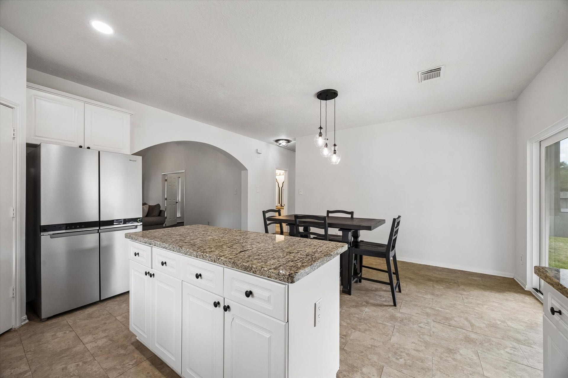 Large kitchen island provides additional prep space and storage while keeping the kitchen open to the dining area.